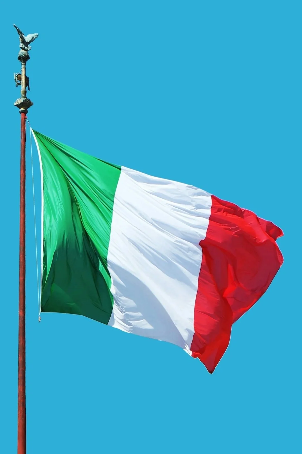 Italian flag waving against a clear blue sky.