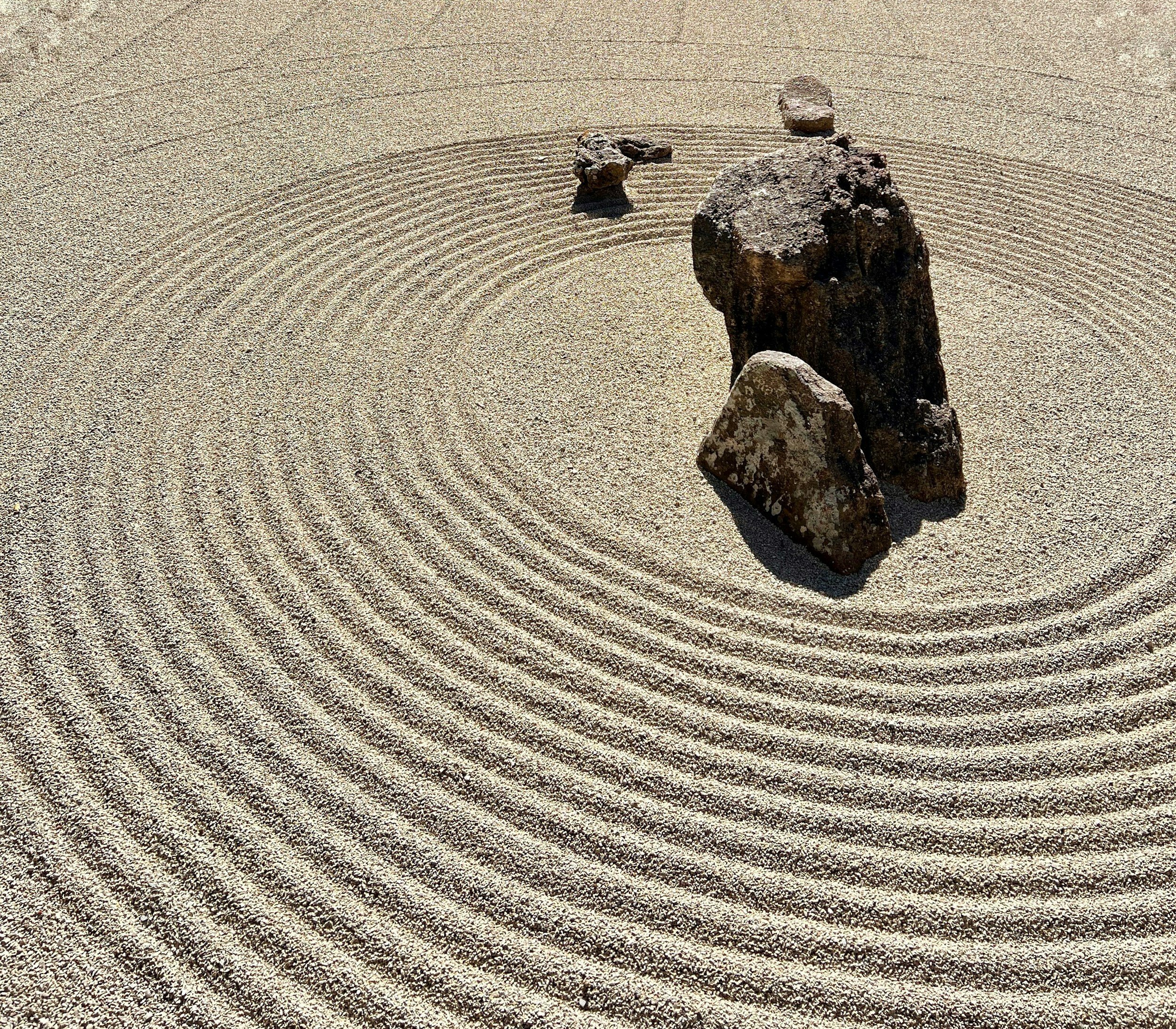 Rocks dans un jardin zen avec motifs de sable ratissés en cercles concentriques.
