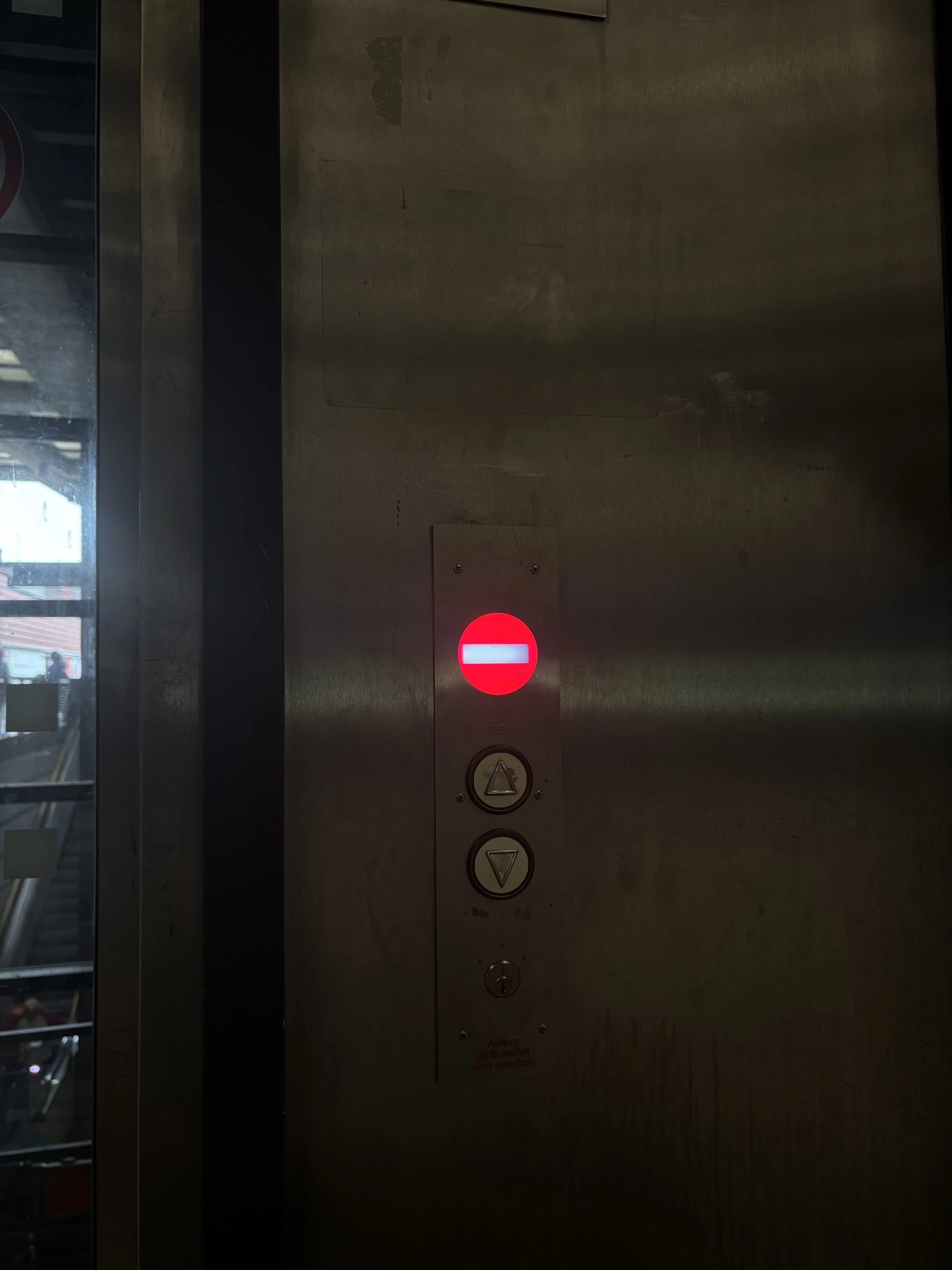Aufzugsknopf mit roter Sicherheits Stoppschaltung in einem Aufzug.