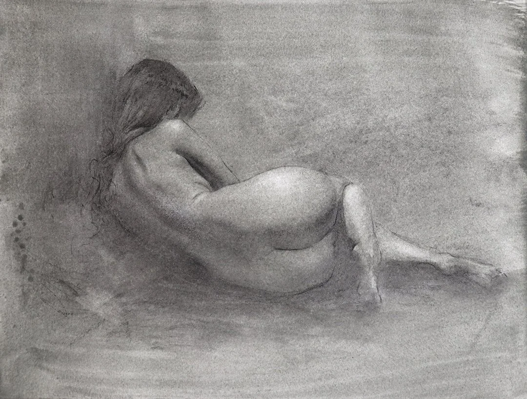 A black and white drawing of a nude woman reclining on her side, with long hair cascading down her back, on a textured surface.