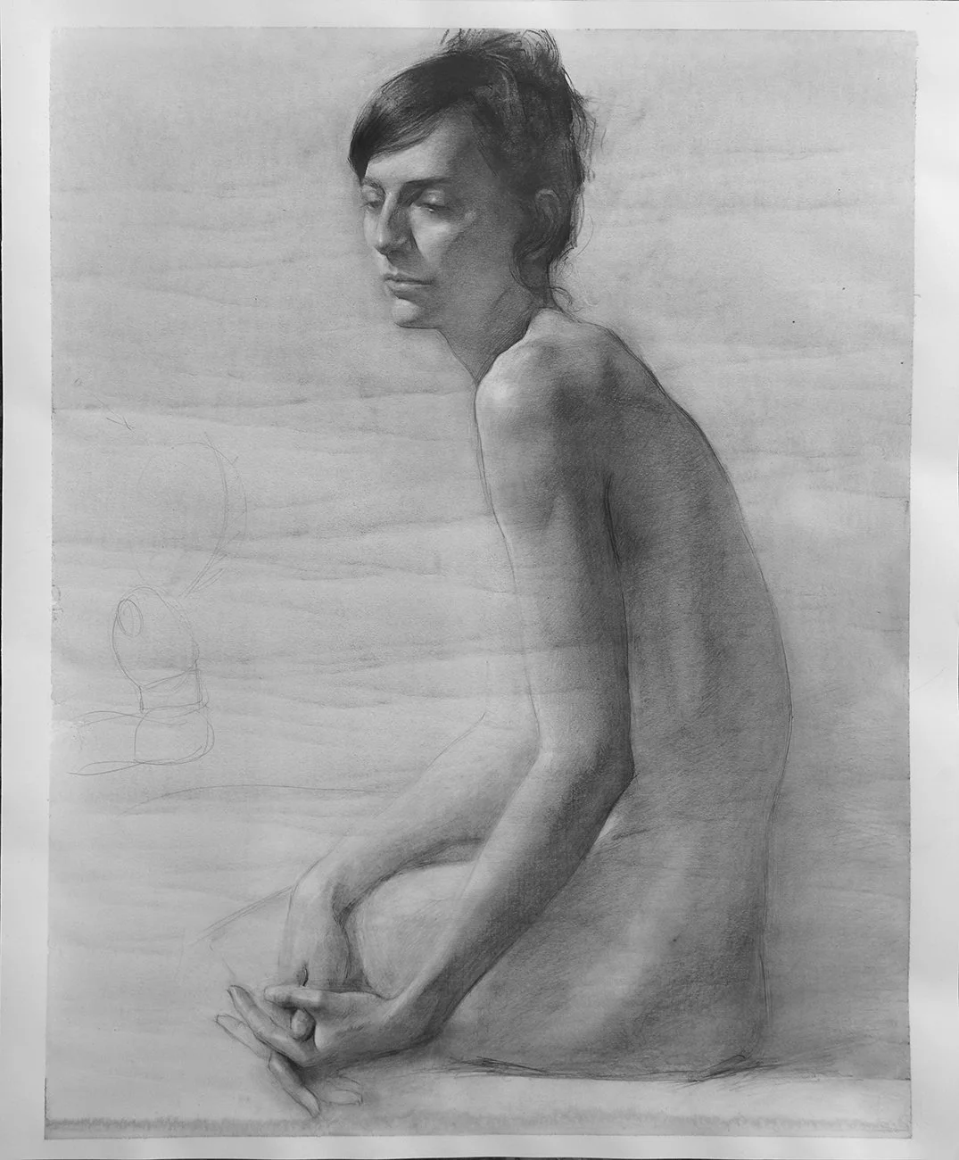 A detailed pencil drawing of a woman sitting with her body turned to the side, head slightly tilted, and eyes closed or looking down. She has short, dark hair and appears to be nude from the waist up, with visible shading that emphasizes her facial f