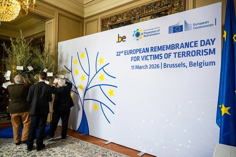 People placing flowers on trees in a ceremony at the 22nd European Remembrance Day for Victims of Terrorism, held on March 11, 2026, in Brussels, Belgium.