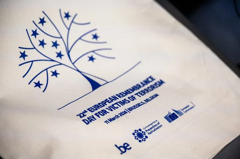 Flyer for the European Remembrance Day for Victims of Terrorism, held on March 11, 2023 in Brussels, Belgium, featuring a blue stylized tree with stars as leaves, logos of the European Union Radiation Protection and European Union, and the website be