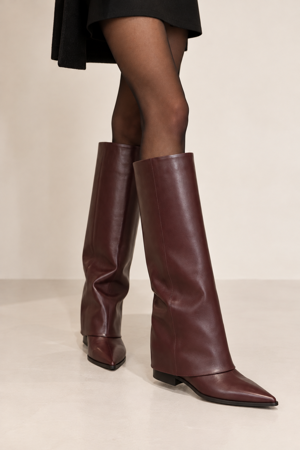 Elegante burgunderrote Stiefel im Studio.png