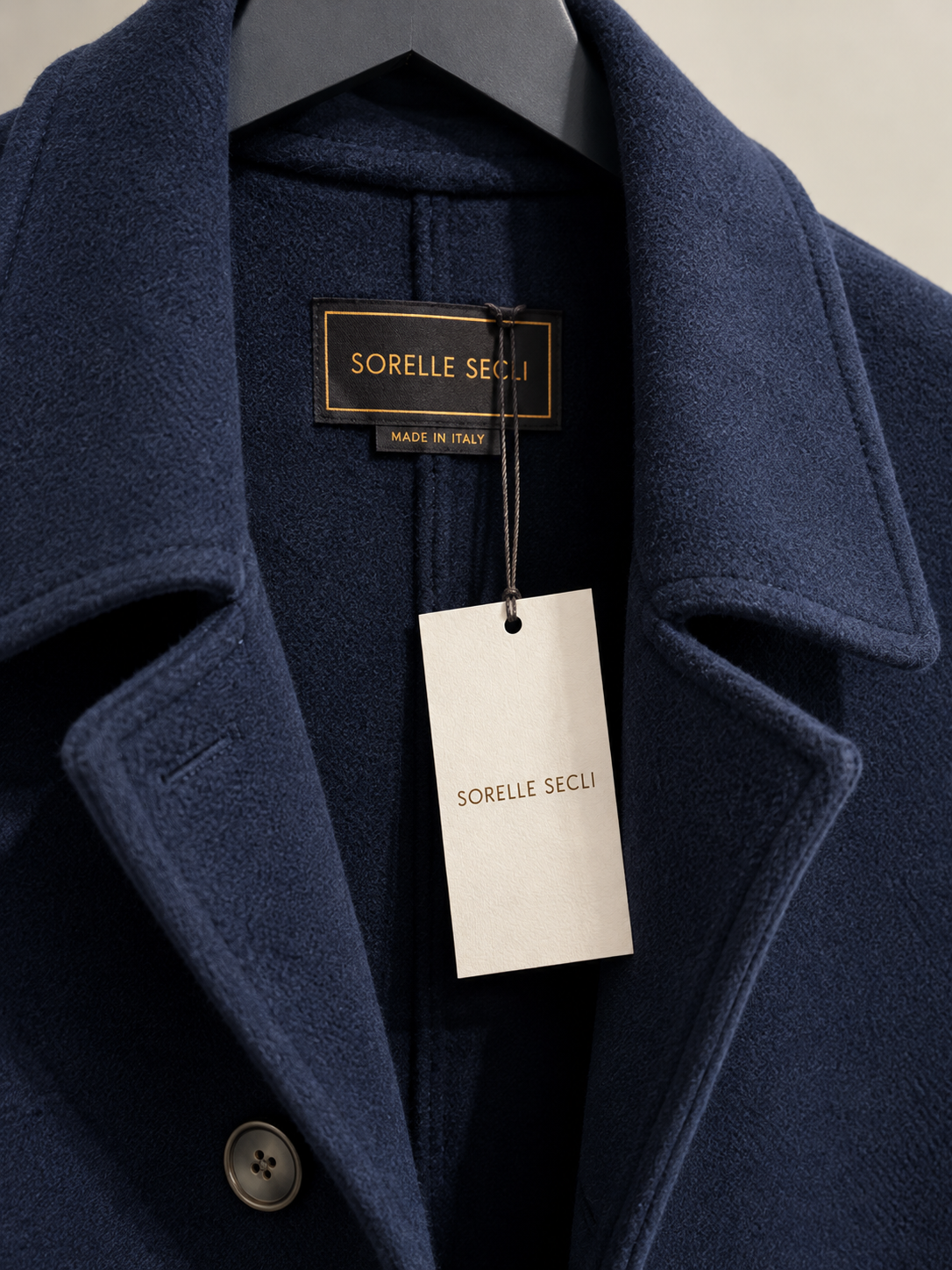 Marineblauer Wollmantel mit Etikett.png