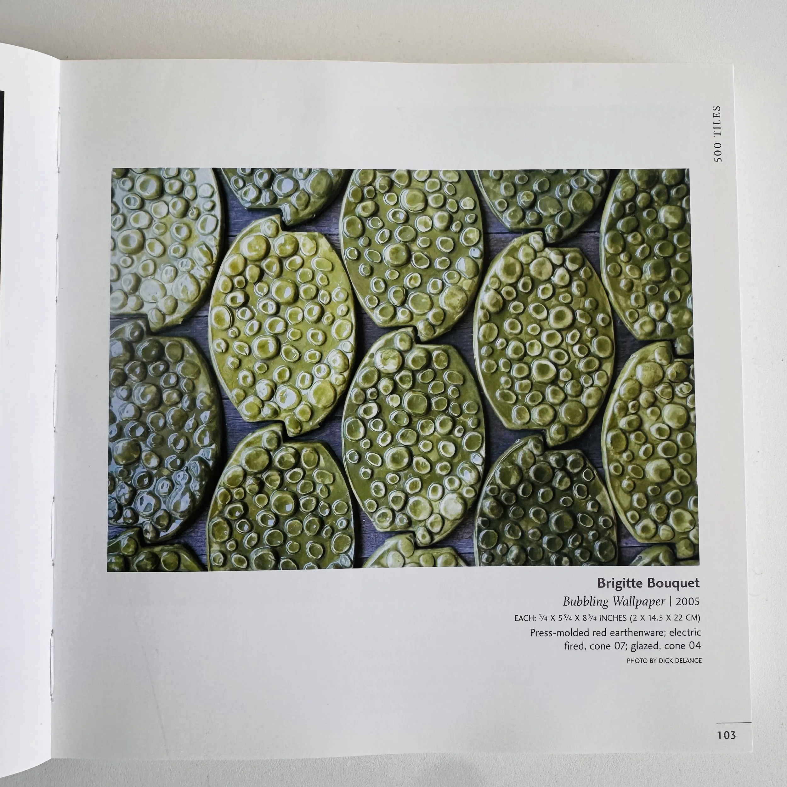 A computer screen displaying a wallpaper titled 'Bubbling Wallpaper' by Brigitte Bouquet, featuring an arrangement of green, bubbling, oval-shaped objects resembling a textured surface.