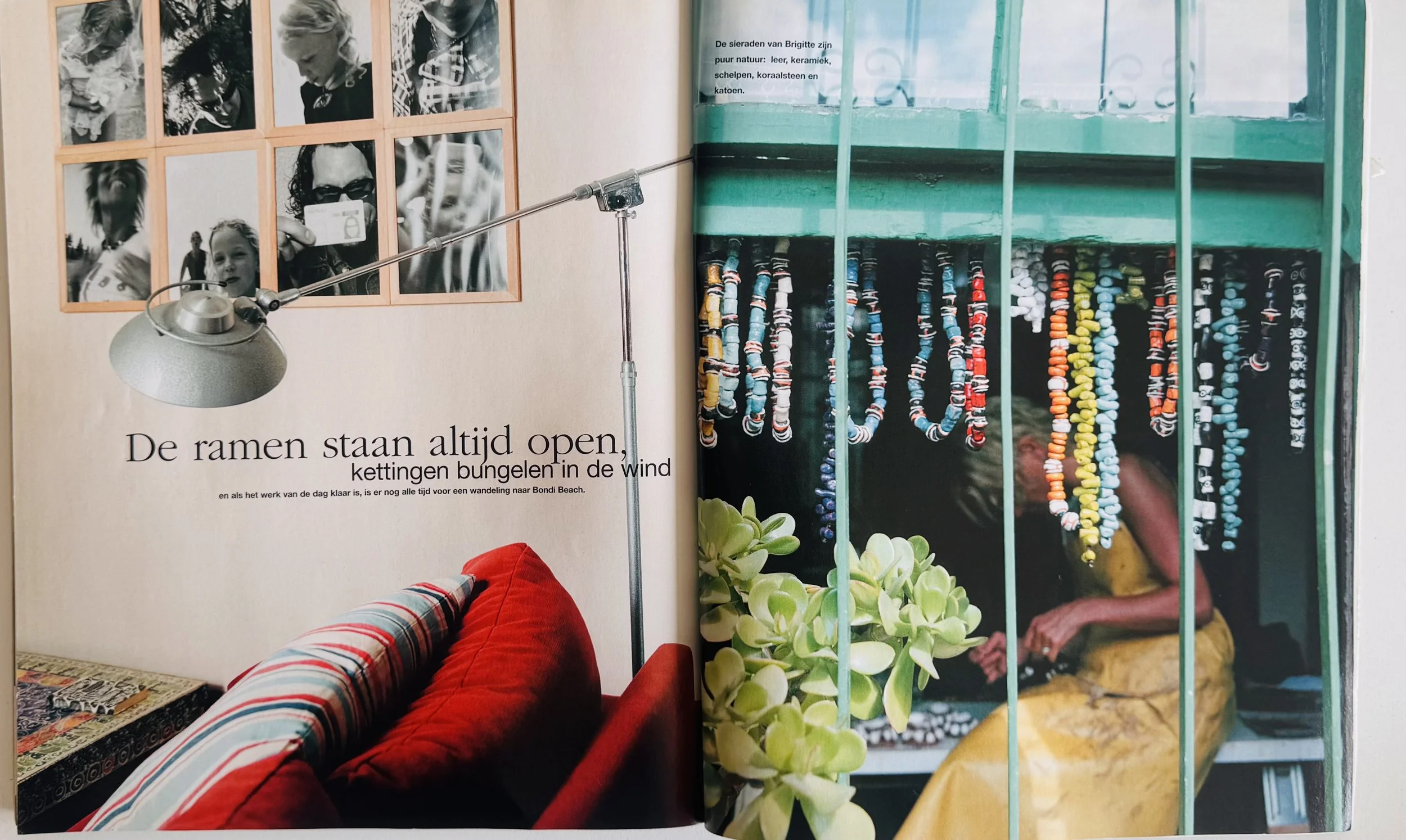 Photo of a living room with a red couch, photo collage on the wall, and a lamp. Next to it, a person is seen through window bars, with colorful shell necklaces hanging outside.