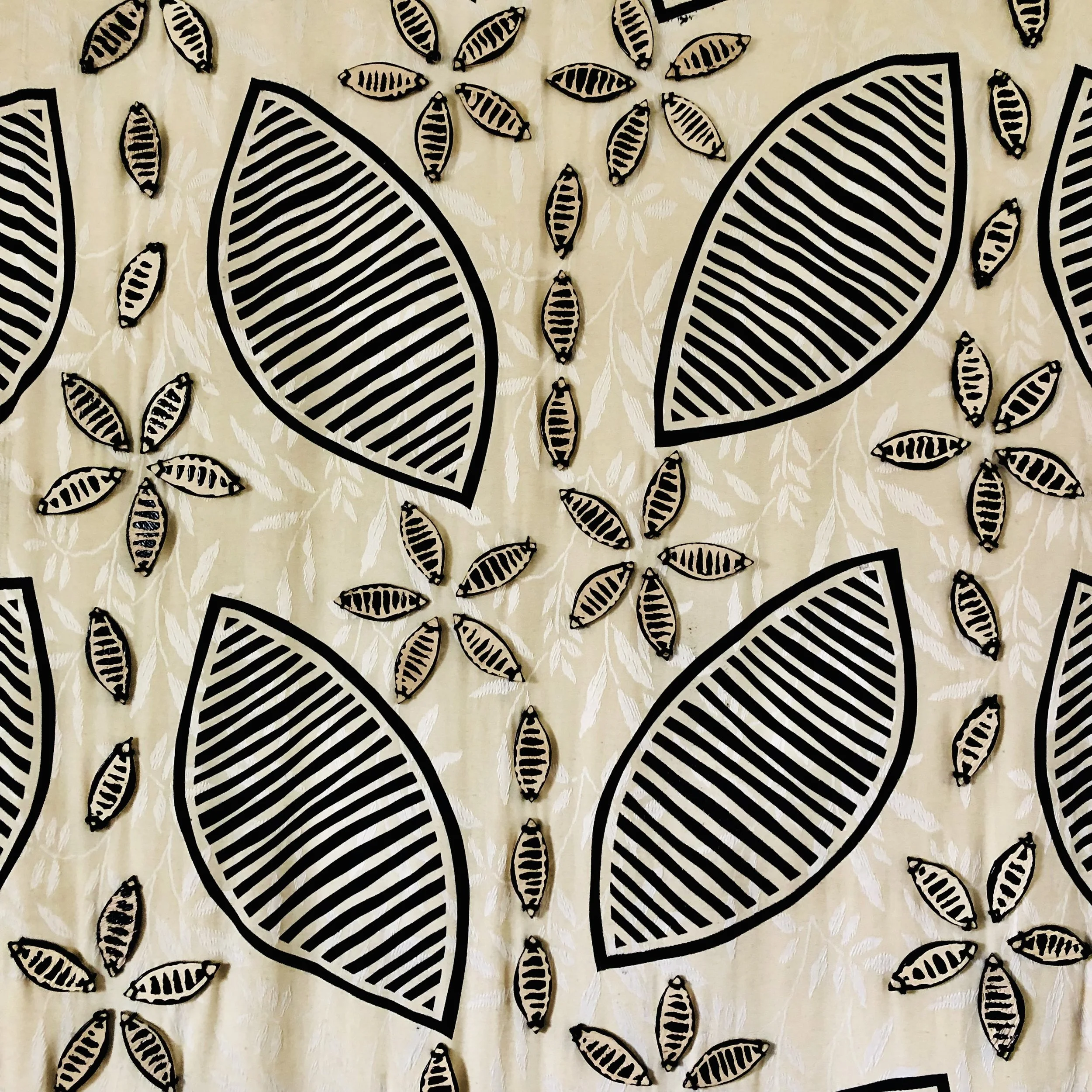 Pattern with large black-striped leaves and smaller floral designs on a cream background.