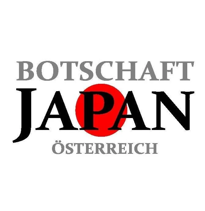 Logo with the words "Botshaft Japan" in large black and gray fonts and "Österreich" in gray font below, with a red circle behind the word "Japan".