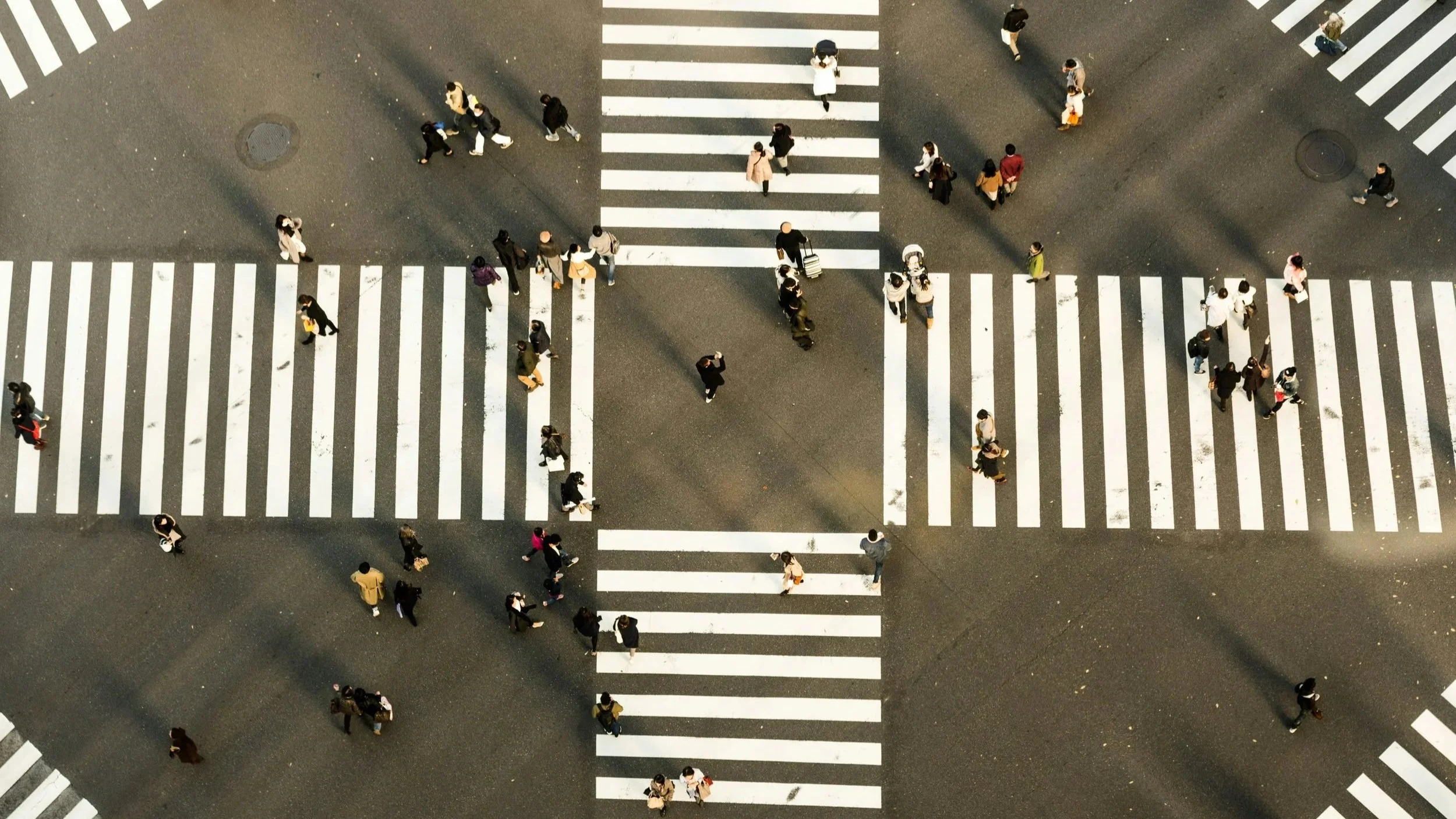 people walking through a crossroads contemplating ways their logical experience and heightened emotions at times don't match in non-monogamy, headed to coaching to work on relational skills.