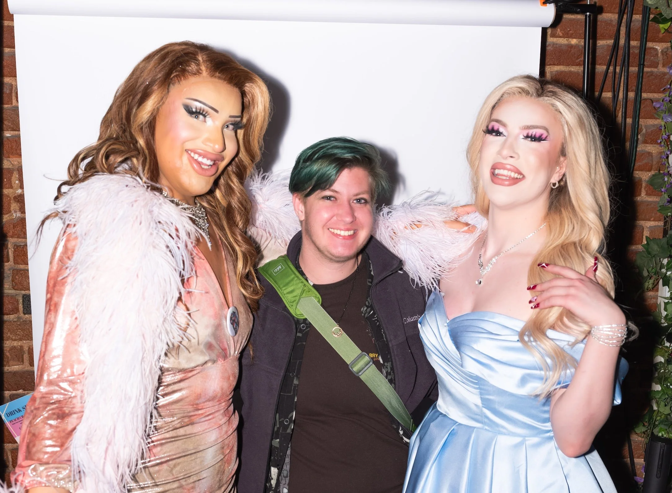 Professional Event Photography by Minneapolis Photographer Jay Cupcake. Three people, two with glamorous makeup and costumes, posing together in front of a white backdrop.