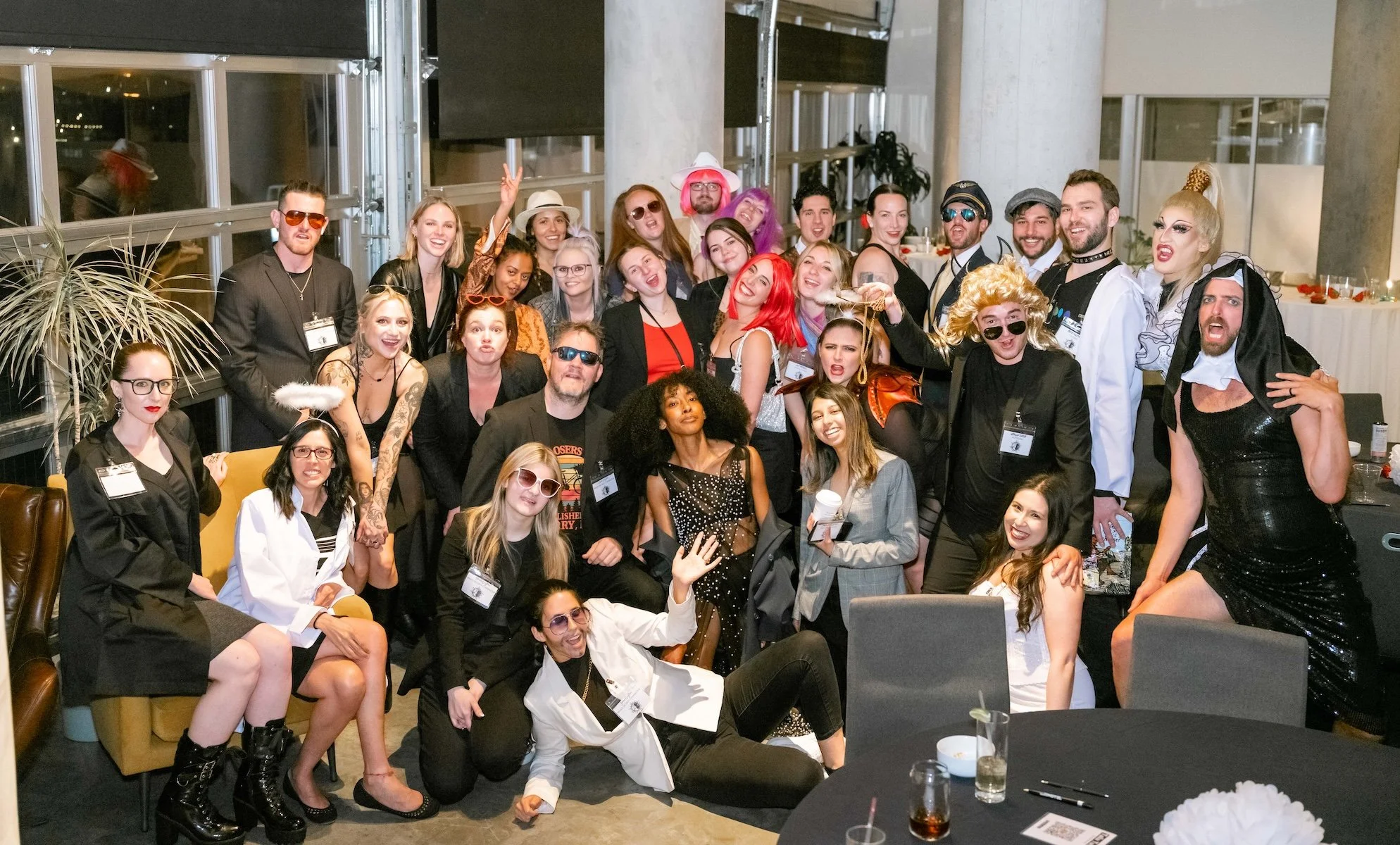 Professional Event Photography by Twin Cities Photographer Jay Cupcake. Group of people dressed in diverse costumes posing indoors at a party or event, with some making playful gestures and expressions.