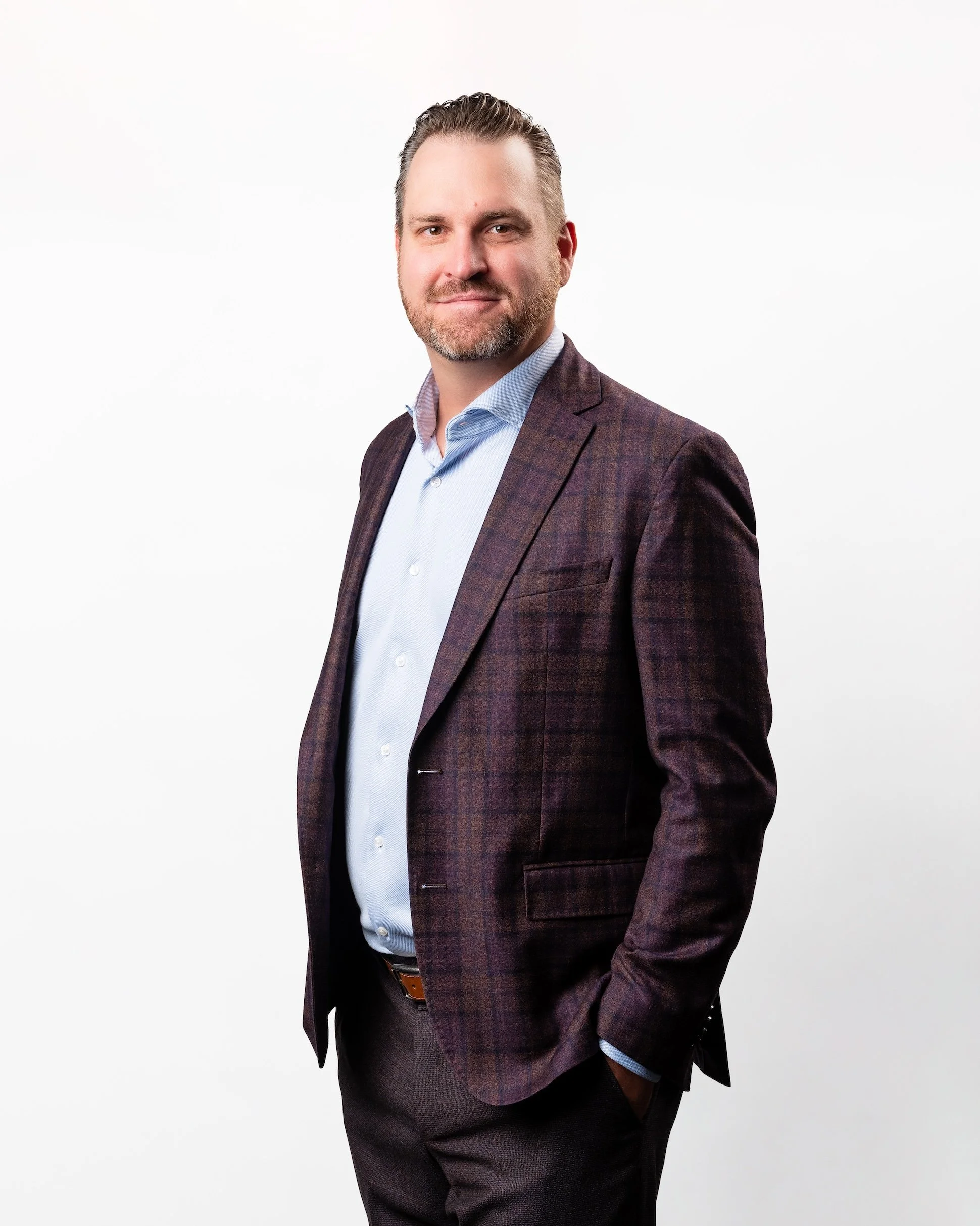 Professional Corporate Headshot by Saint Paul Photographer Jay Cupcake. A man in business attire standing against a white background.