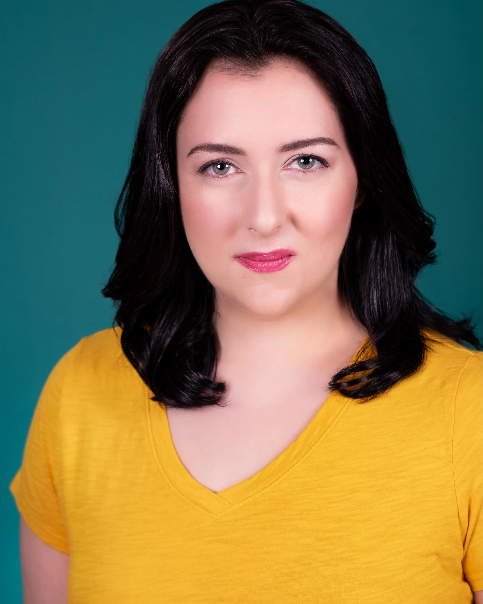 Professional Actor Headshot by Minneapolis Photographer Jay Cupcake. A woman with dark hair wearing a yellow top against a teal background.