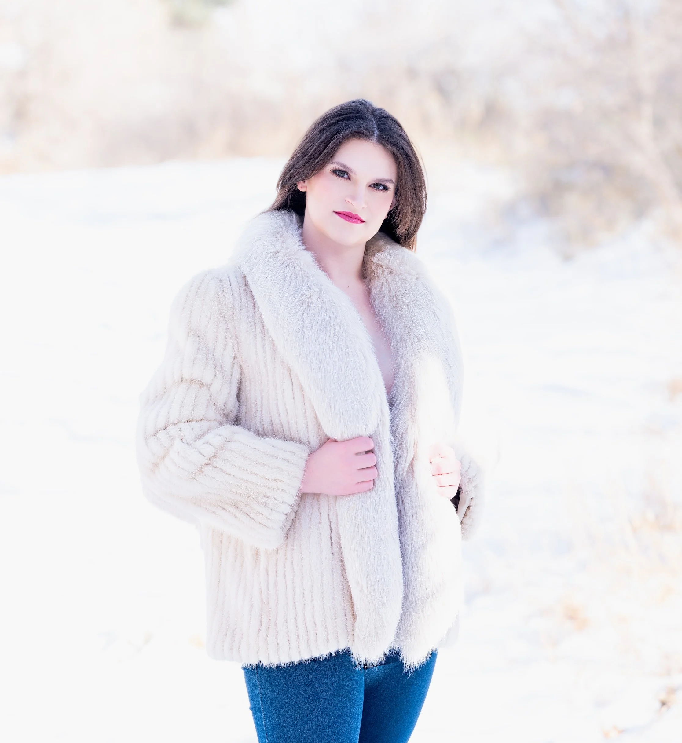 Professional Portrait Photography by Minneapolis Photographer Jay Cupcake. Woman wearing a cream-colored fur coat standing in a snow-covered landscape.