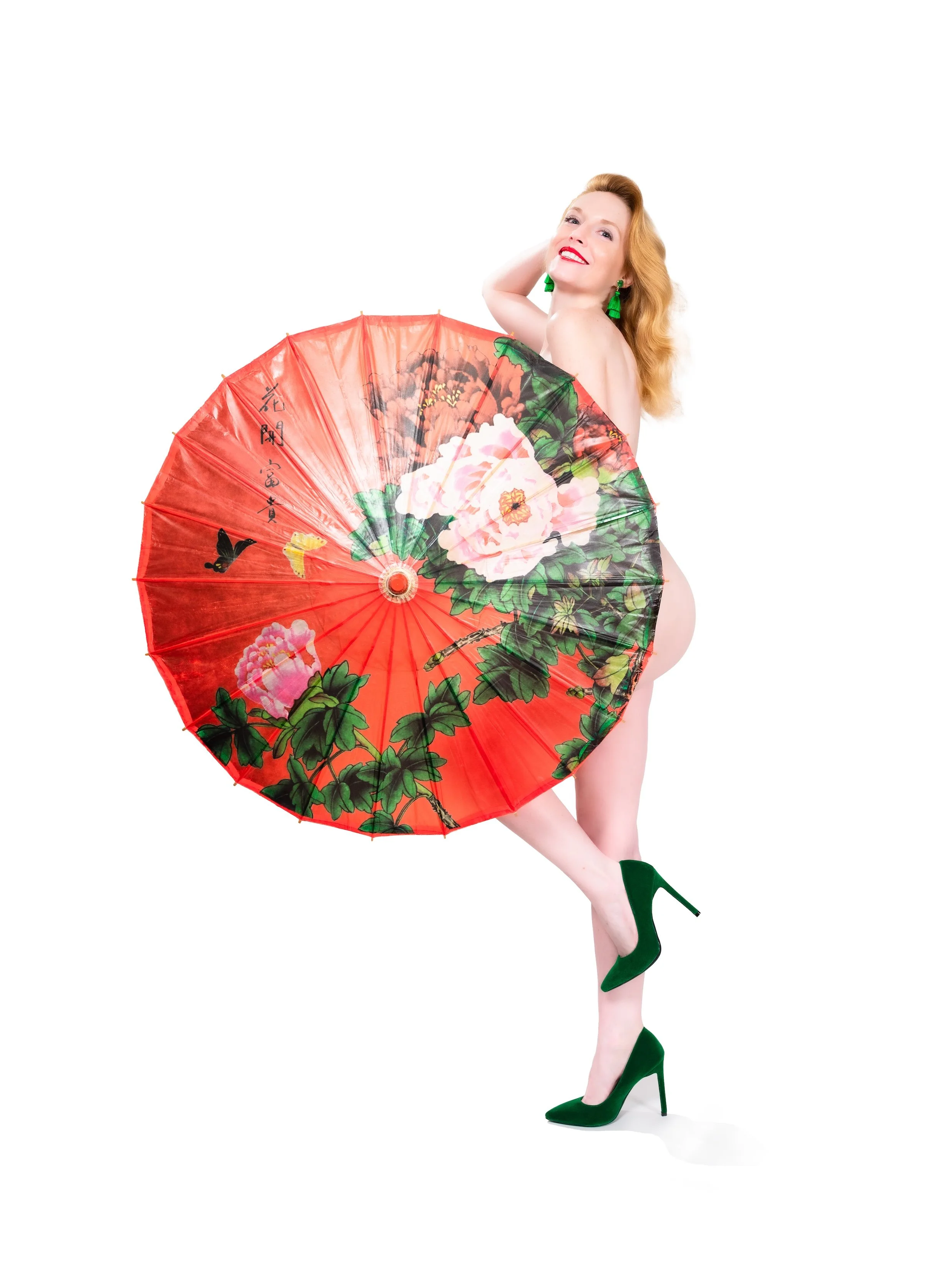 Professional Portrait Photography by Twin Cities Photographer Jay Cupcake. A woman with red hair and green earrings, wearing green high heels, holding a large decorative Asian parasol with floral and butterfly patterns, standing against a plain white