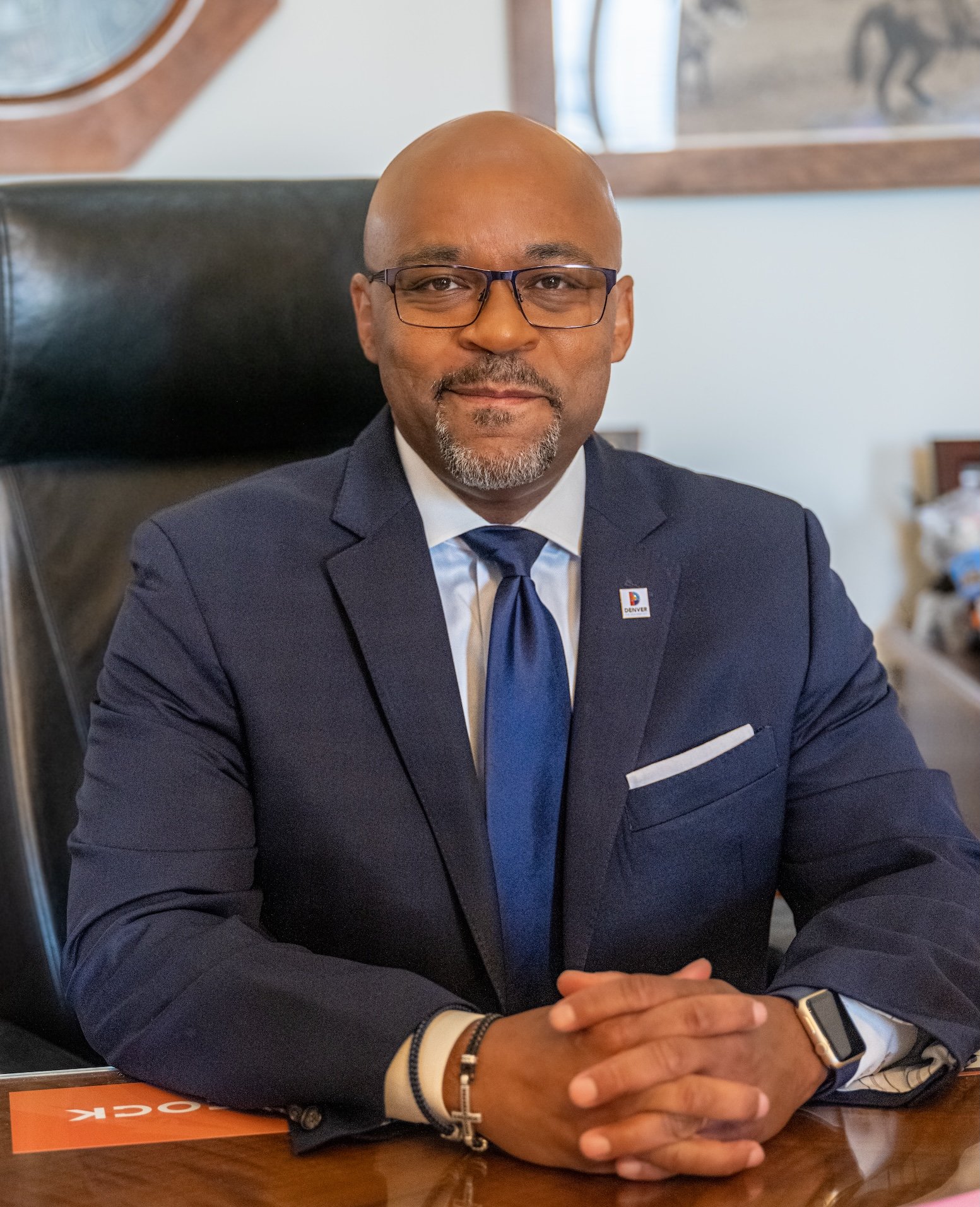 Professional Portrait Photography by Twin Cities Photographer Jay Cupcake. A man in a suit with glasses and a beard, sitting at a desk in an office.