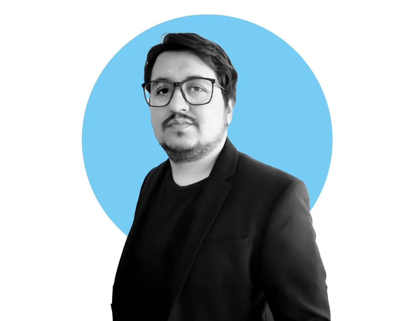 Black and white photo of a man wearing glasses, a black blazer, and a black shirt, standing in front of a blue circle background.