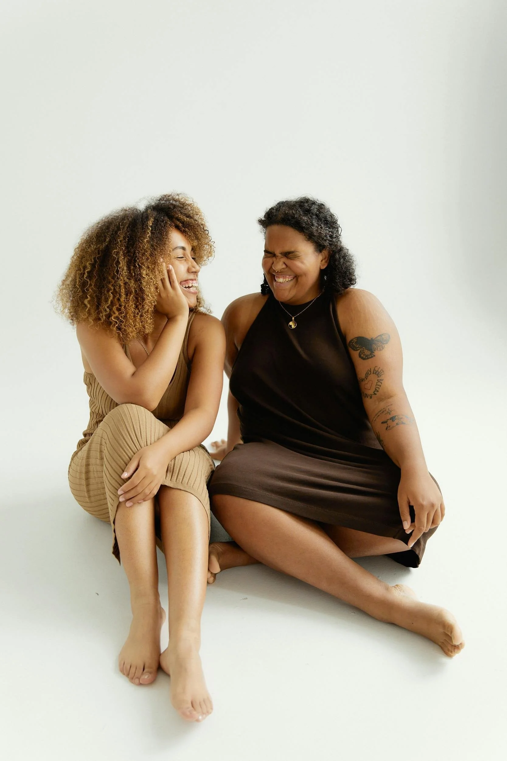 Two women sitting together laughing