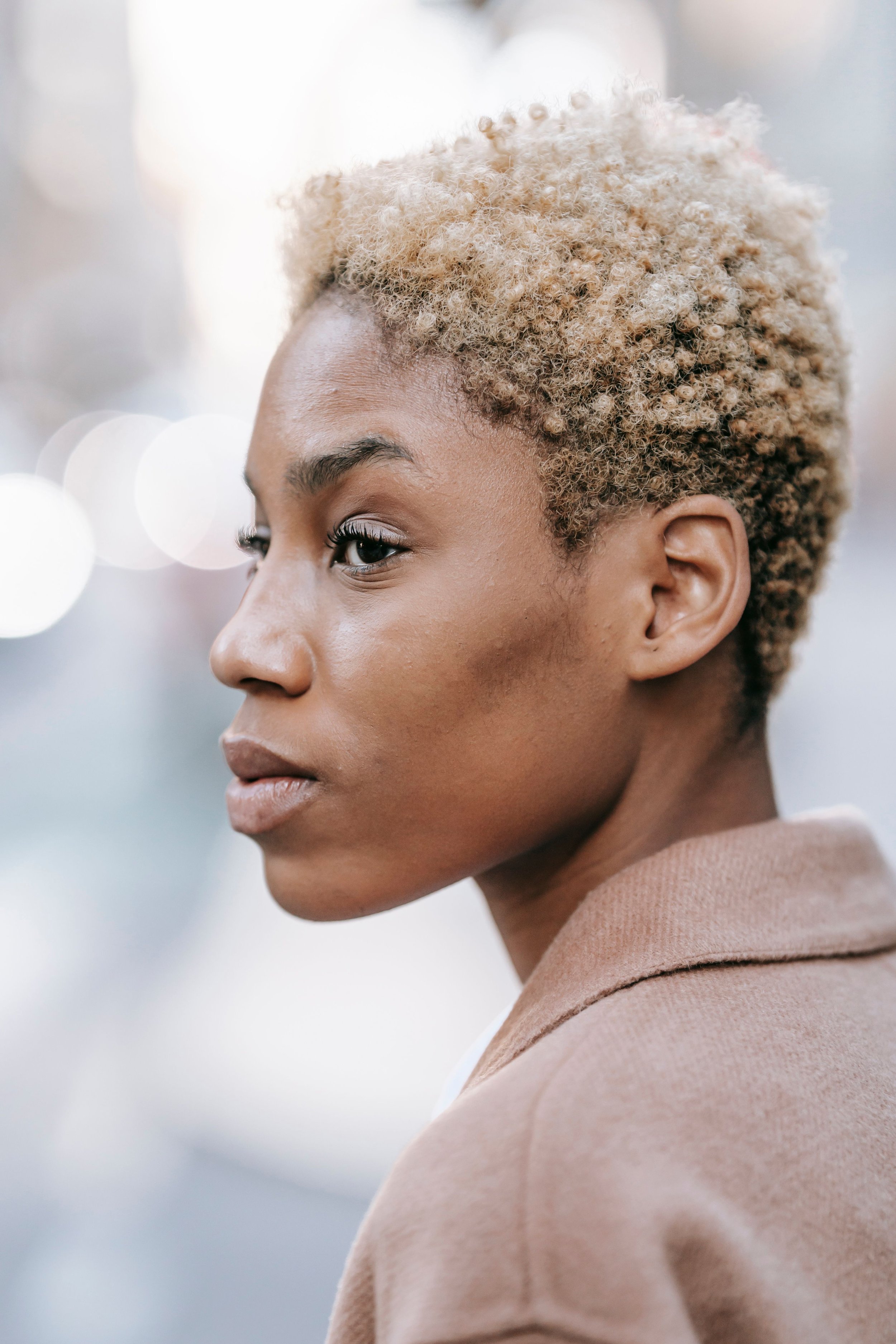 A Black woman in a quiet, reflective moment, representing the generational weight of the strong Black woman schema and the exhaustion that comes from carrying it without acknowledgment.