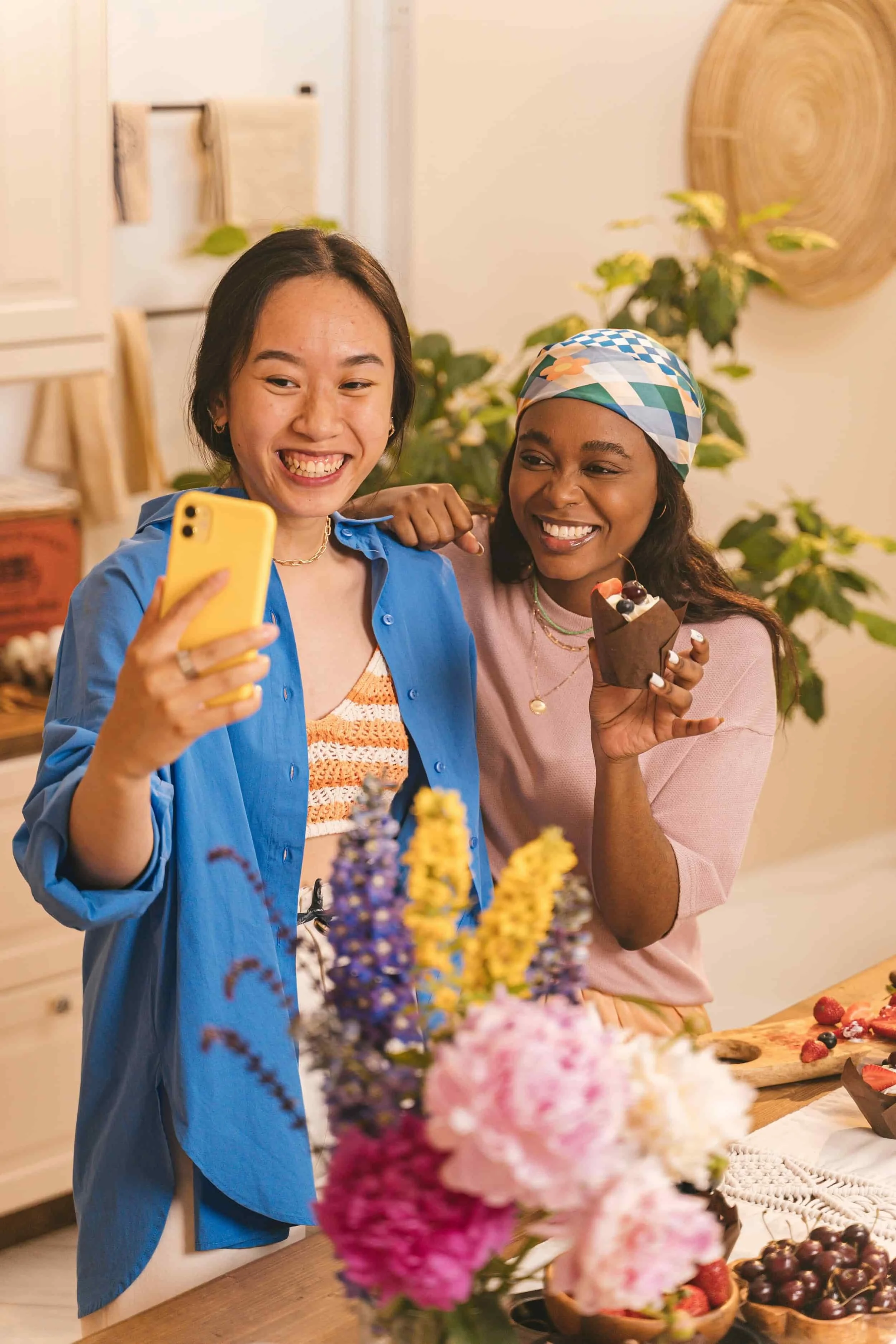 two women in a kitchen smiling and taking a selfie together