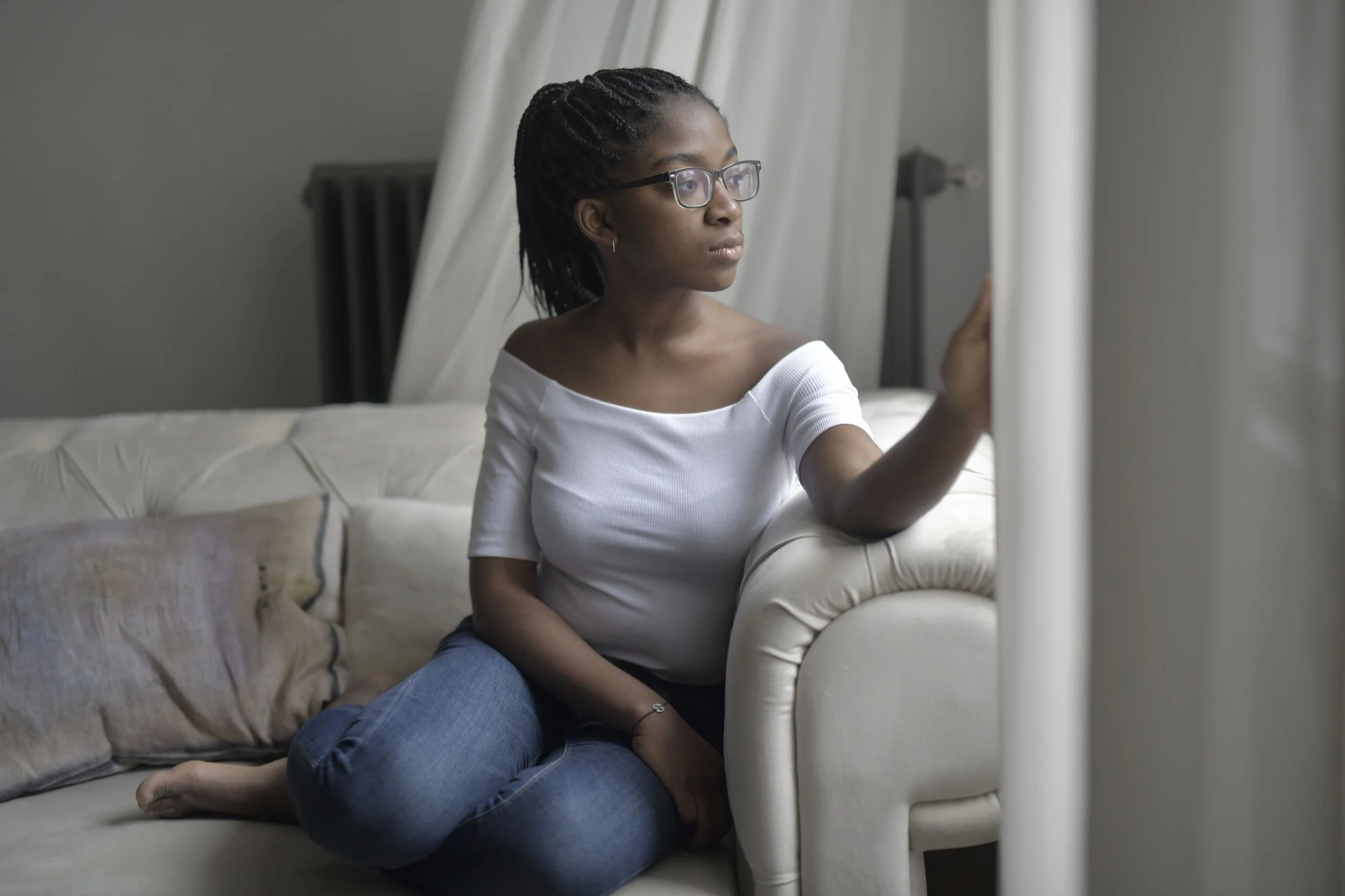 A Black woman sitting thoughtfully, representing the experience of dating anxiety and repeating relationship patterns that attachment-based therapy addresses in New York and New Jersey.