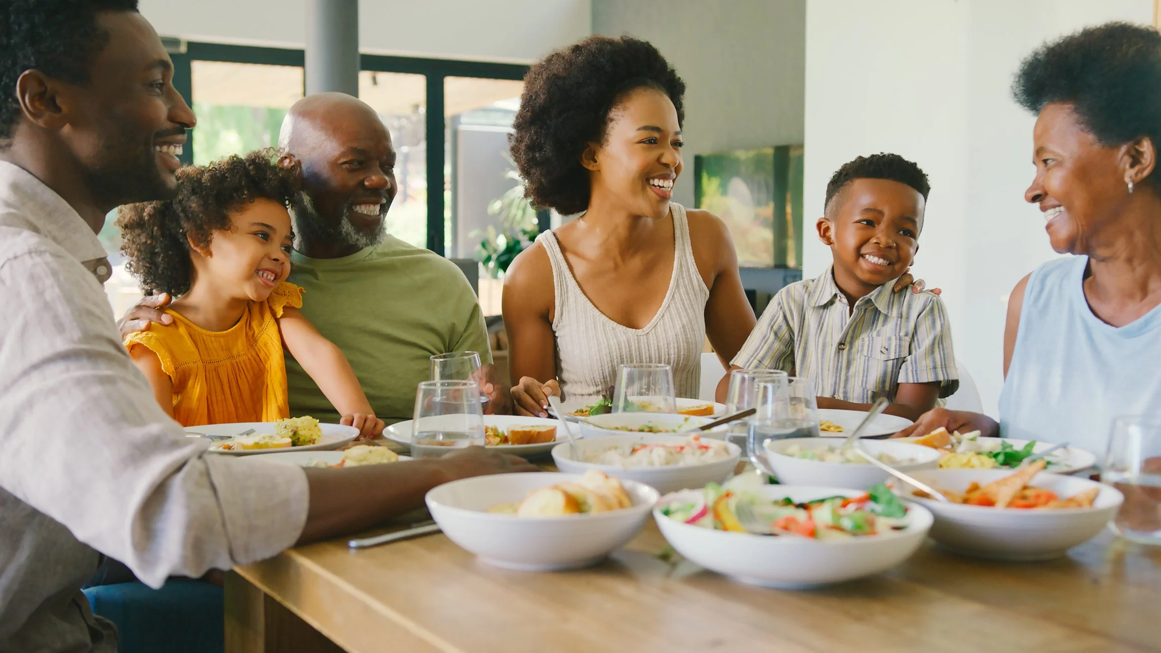 Multi-generational Caribbean family gathered around a dinner table, representing the family dynamics explored in therapy