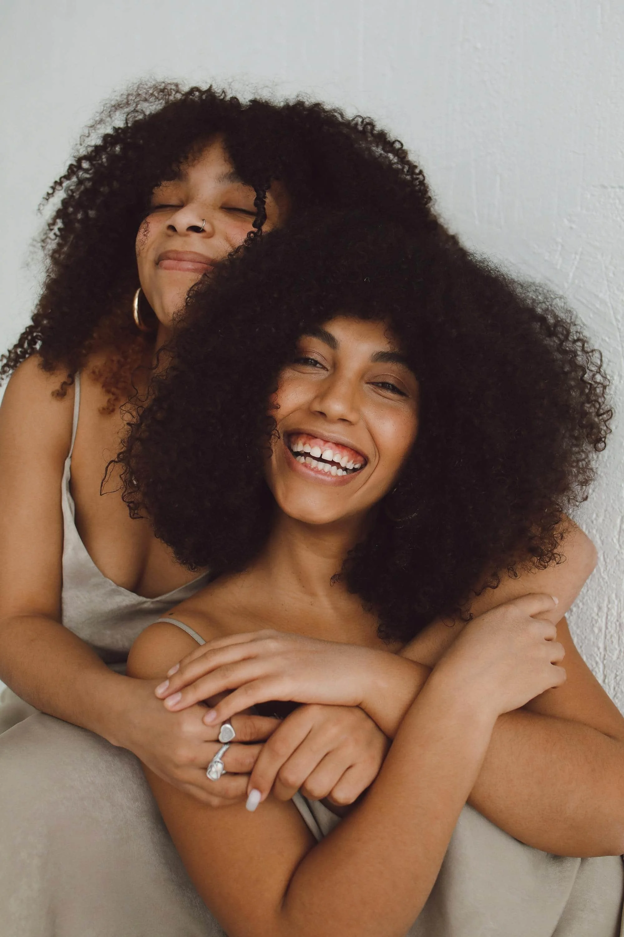 Two women smiling with their arms around each other