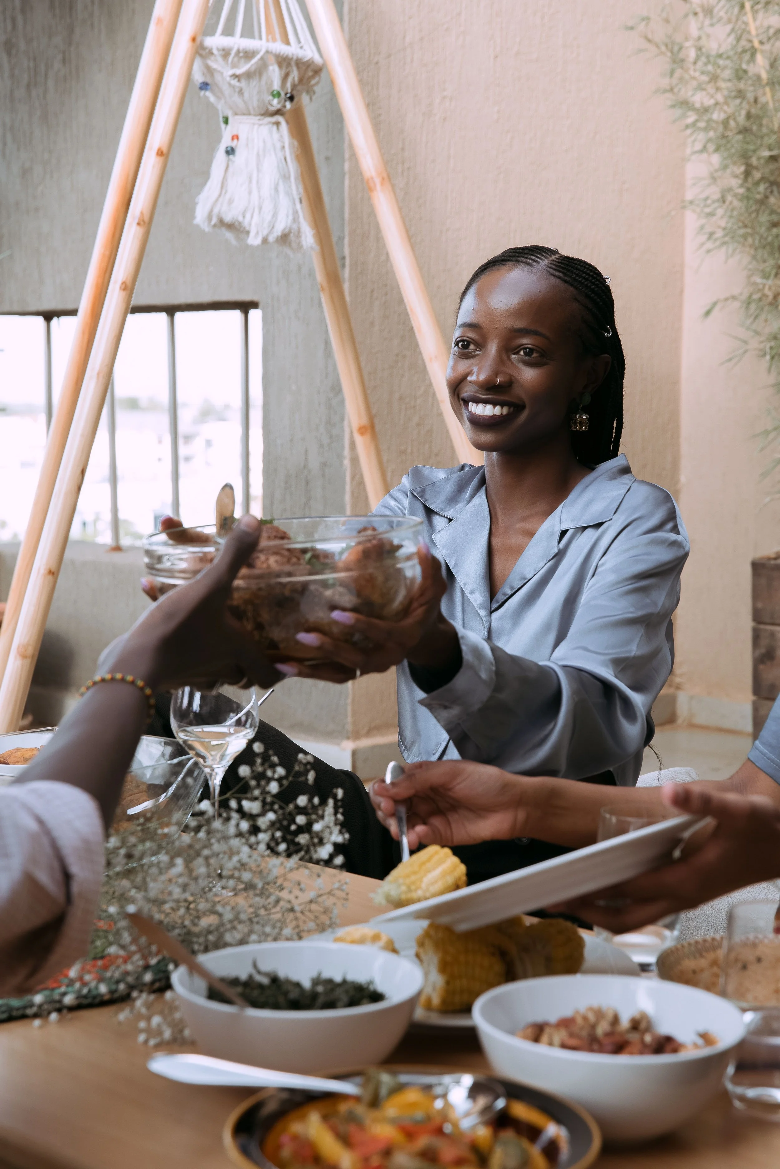 A Black woman at a family gathering with a composed expression that carries a hint of internal tension, representing the nervous system activation that happens when re-entering a family environment.