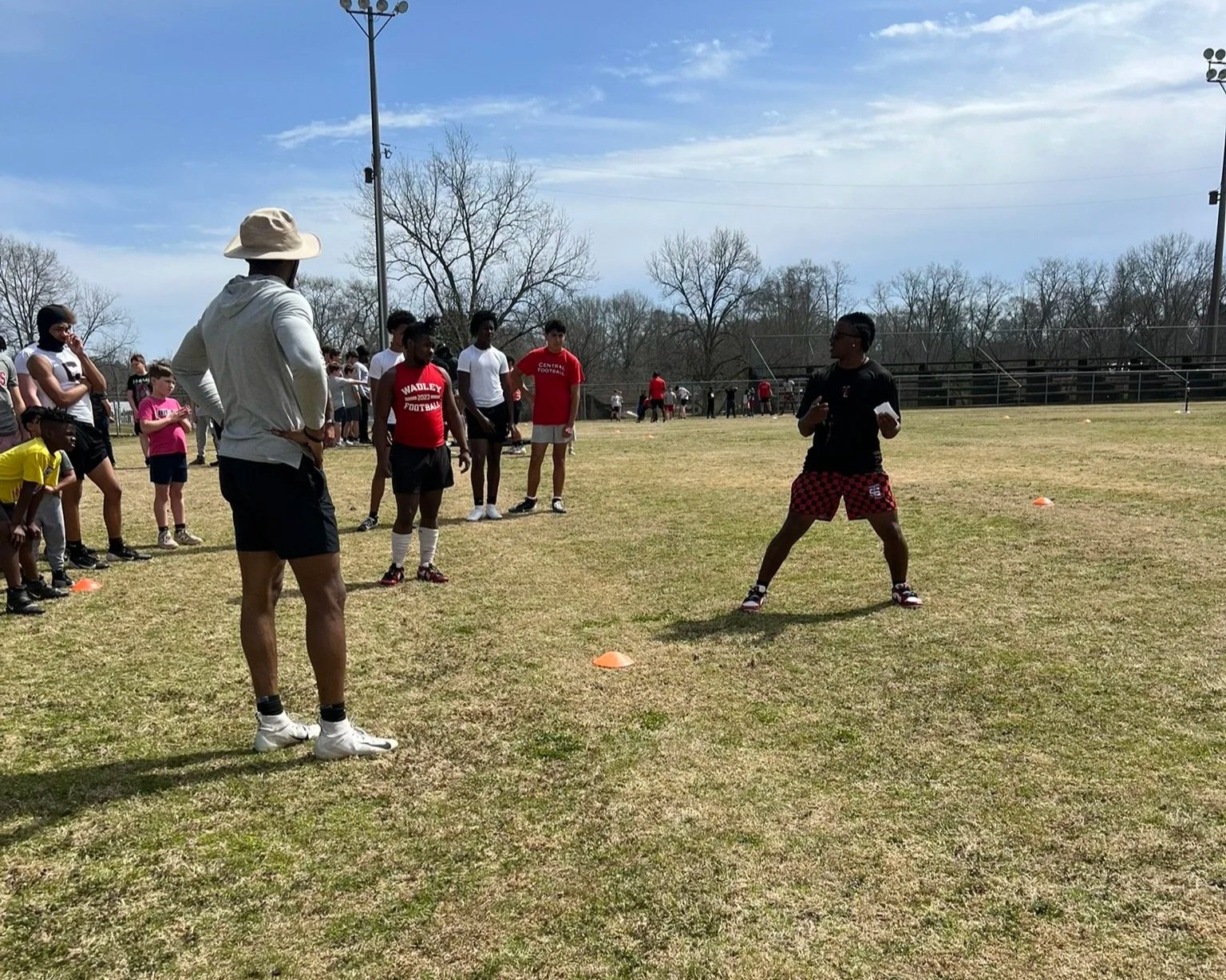 Coach Peoples instructing a youth football player during the Next Level Camp.