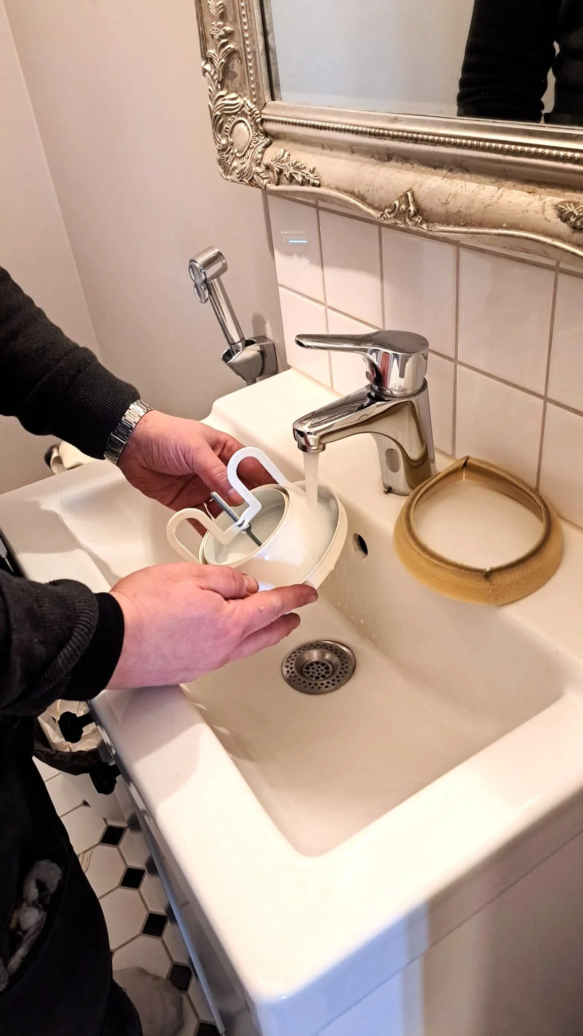 Ilmateknikko Antti Lepikko pesee ilmastointikanavan suojalevyä lavuaarissa.