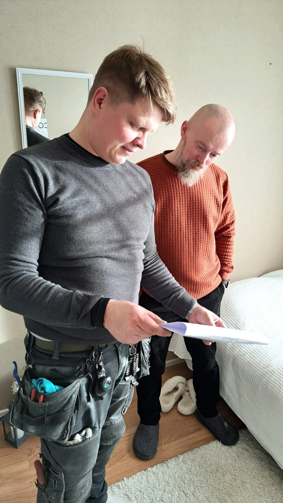 Ilmateknikko Antti Lepikko tutkii asiakkaan kanssa huoneiston ilmanvaihtopiirustusta.