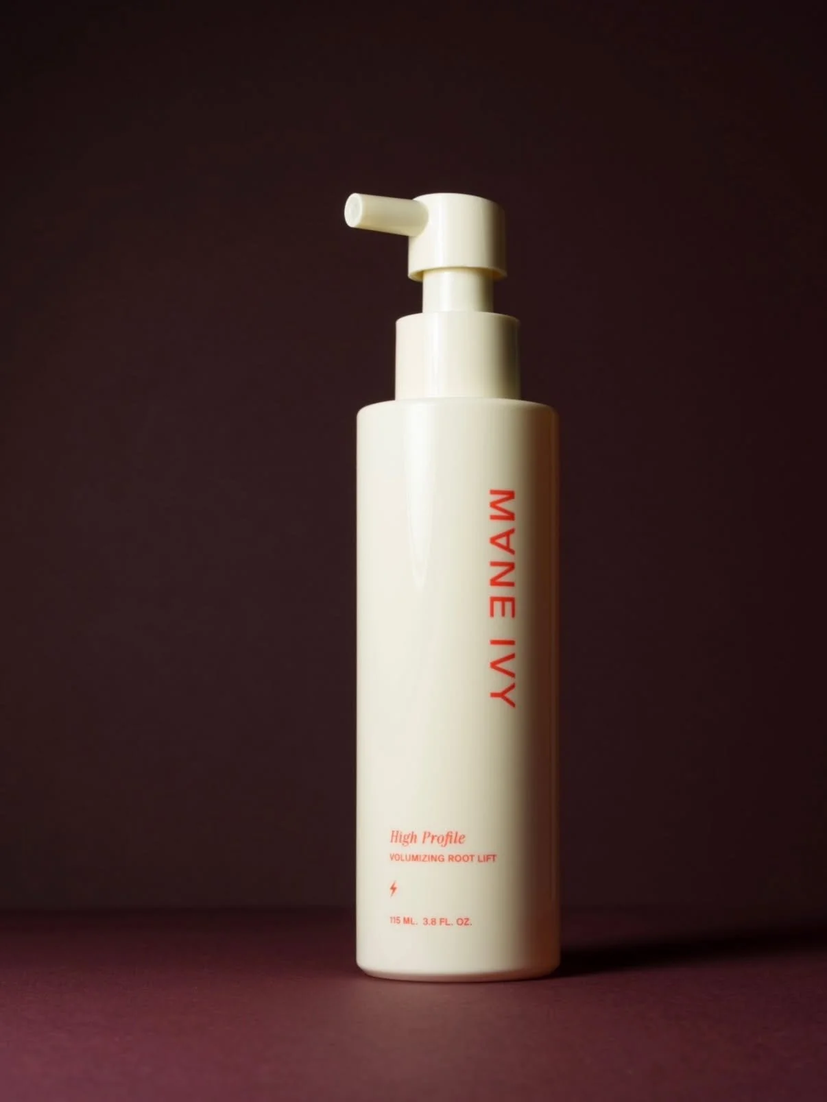 A white bottle with a pump dispenser labeled 'IVEY IVY' in red text, standing on a dark surface against a dark background.
