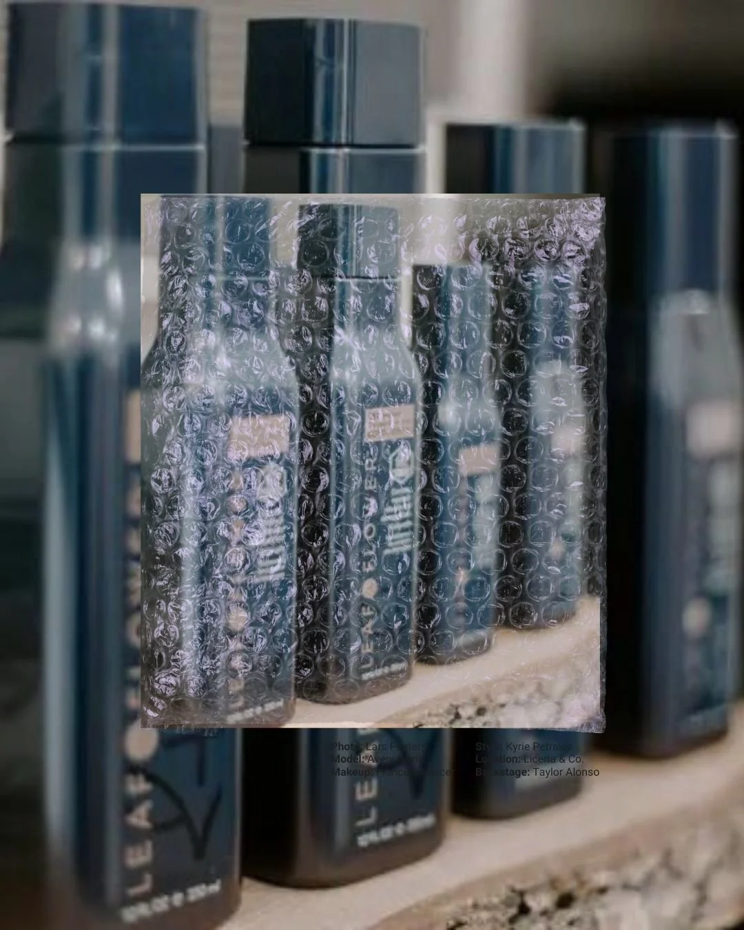 A row of makeup or skincare products in blue packaging, with one box wrapped in bubble wrap.