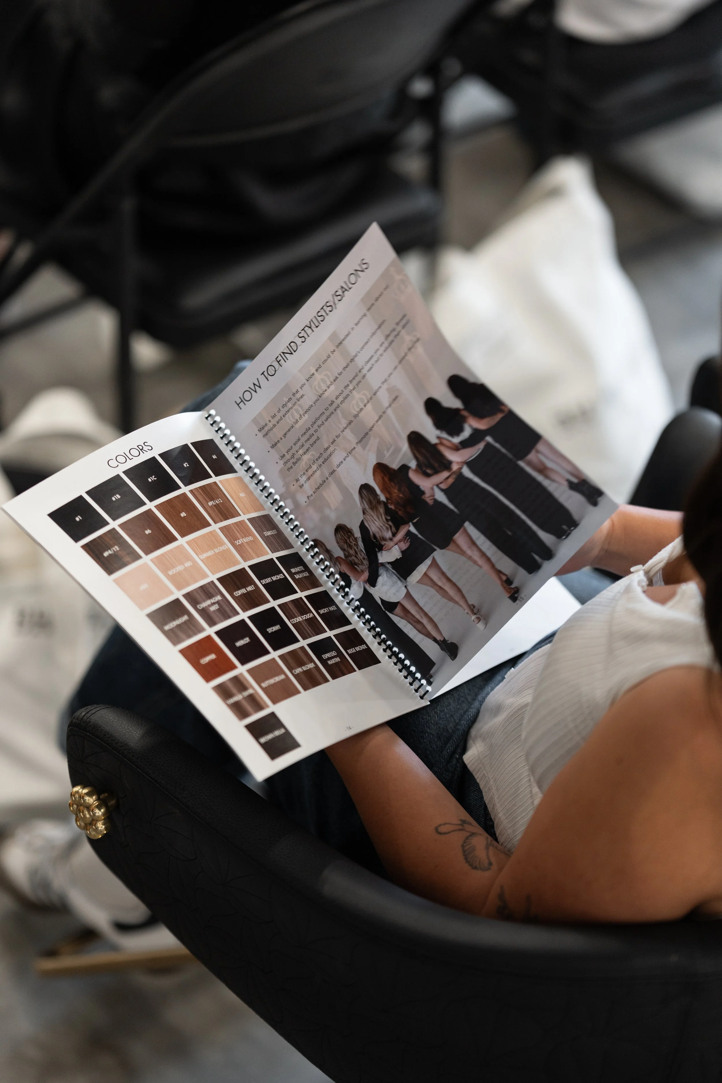Person holding a magazine open to a page with a color chart and a photo of a group of women standing in line.