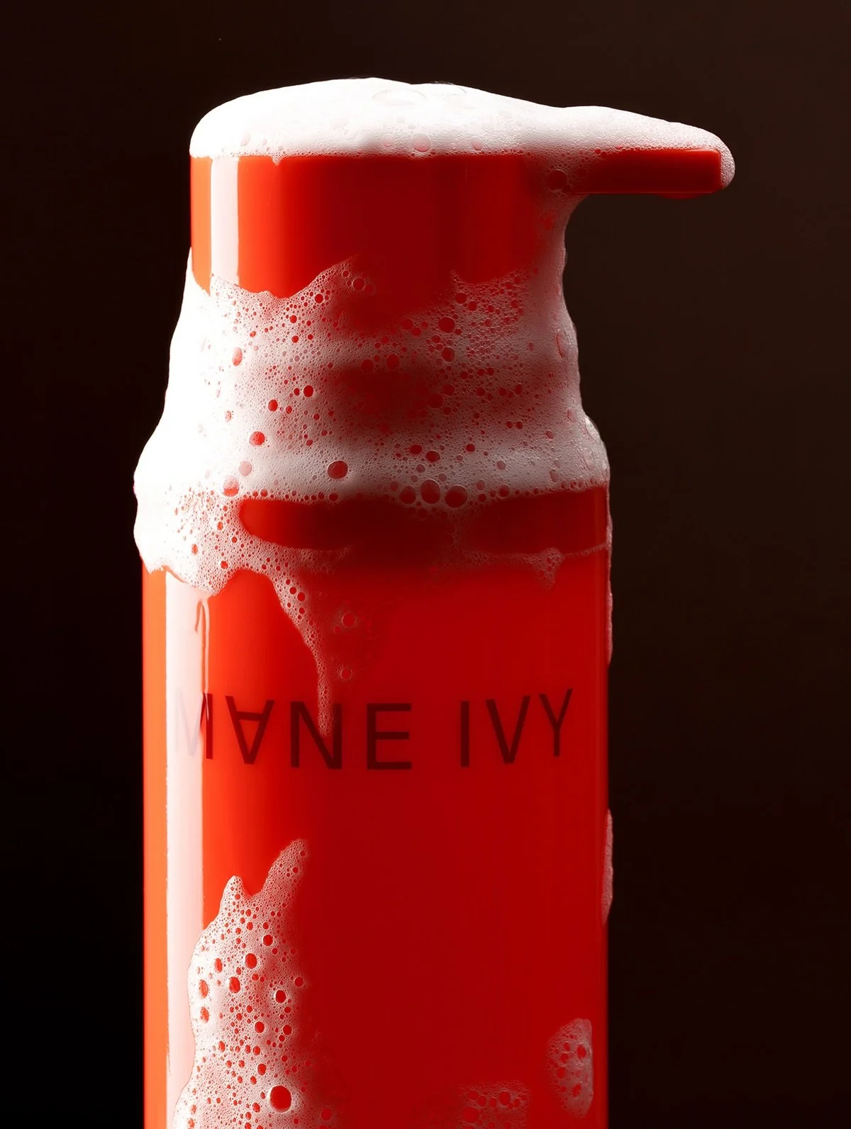 A red can with foam overflowing from the top, labeled 'A I N A' in black letters.