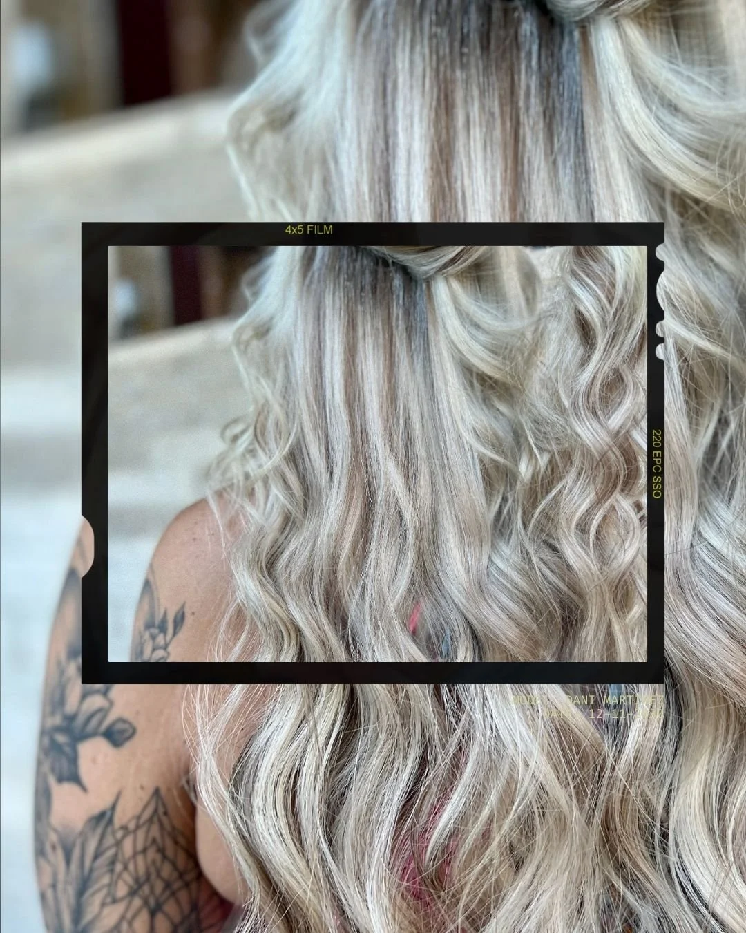 Close-up of blonde, curly hair with an overlay of a vintage camera viewfinder frame and text.