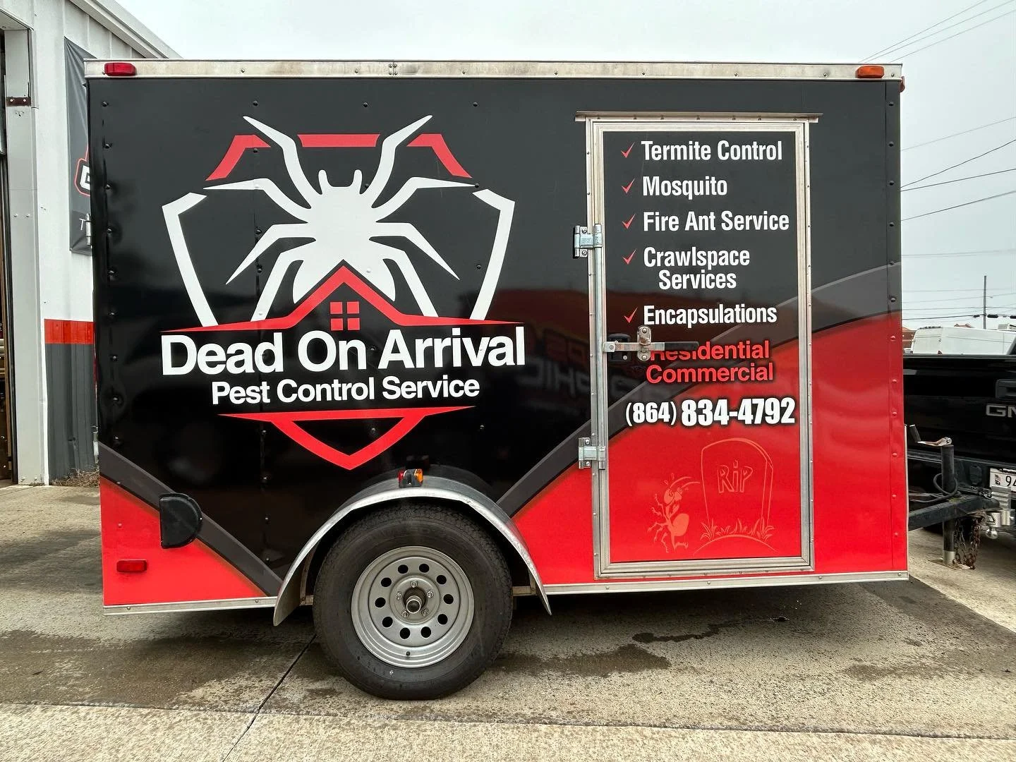 Pest control service trailer with large spider logo and company name 'Dead On Arrival Pest Control Service.' List of services including termite control, mosquito, fire ant service, crawlspace services, and encapsulations. Contact phone number: (864) 