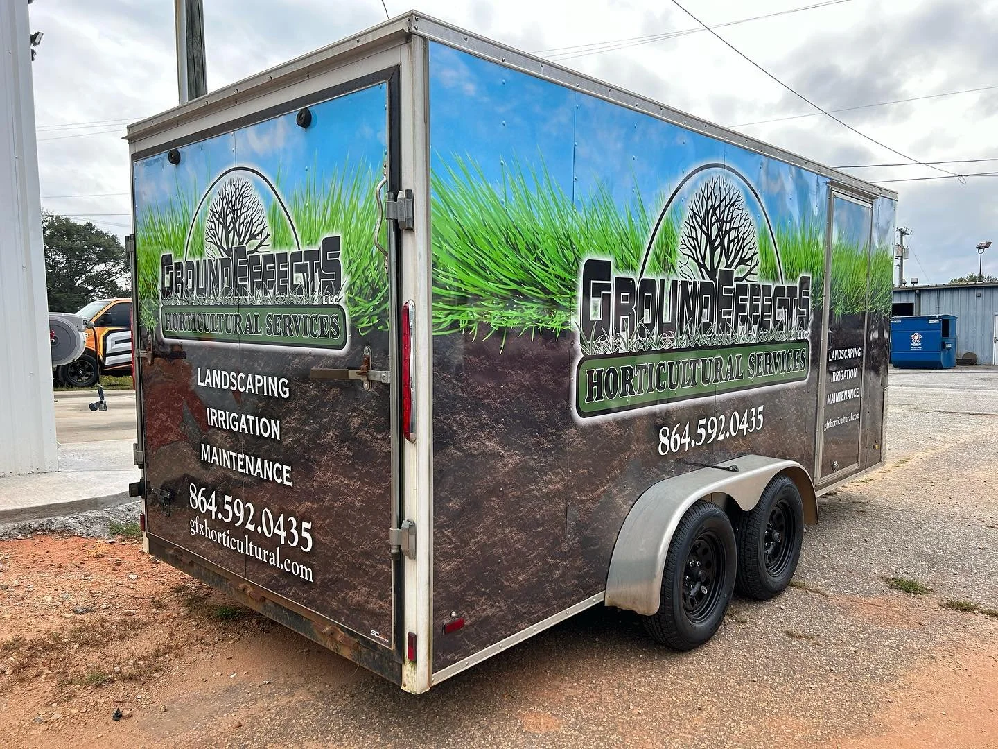 A trailer advertising Ground Effects Horticultural Services, with services listed as landscaping, irrigation, and maintenance, with a phone number and website displayed.