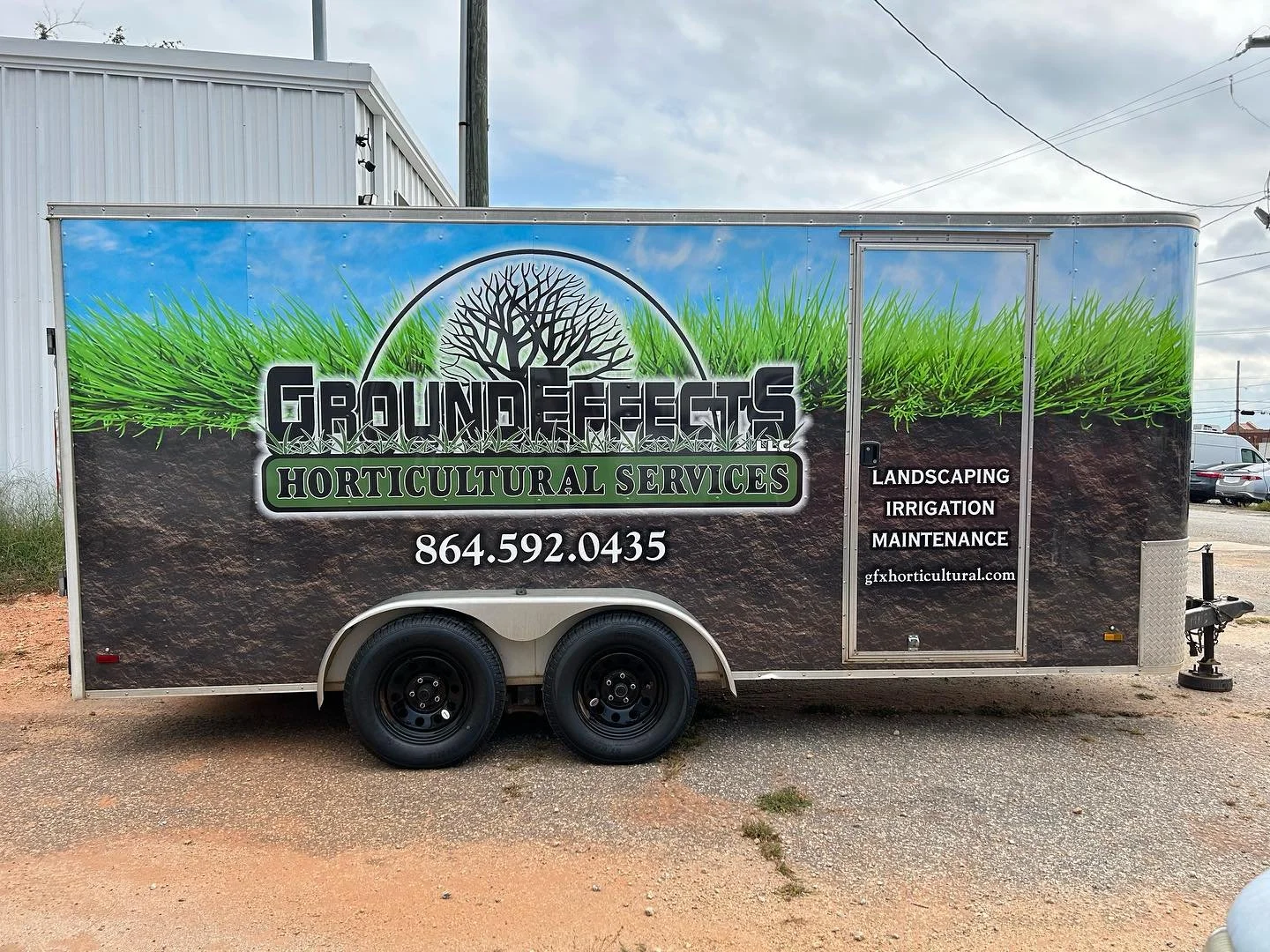 A mobile trailer banner advertising Ground Effects LLC, a horticultural services company, featuring a graphic of grass and a tree, with the company name, phone number, services (landscaping, irrigation, maintenance), and website.