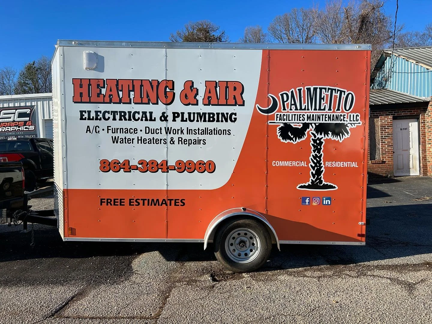 A red and white commercial trailer advertising heating, air, electrical, and plumbing services with contact number 864-384-9960, free estimates, and social media icons, parked outside a building.