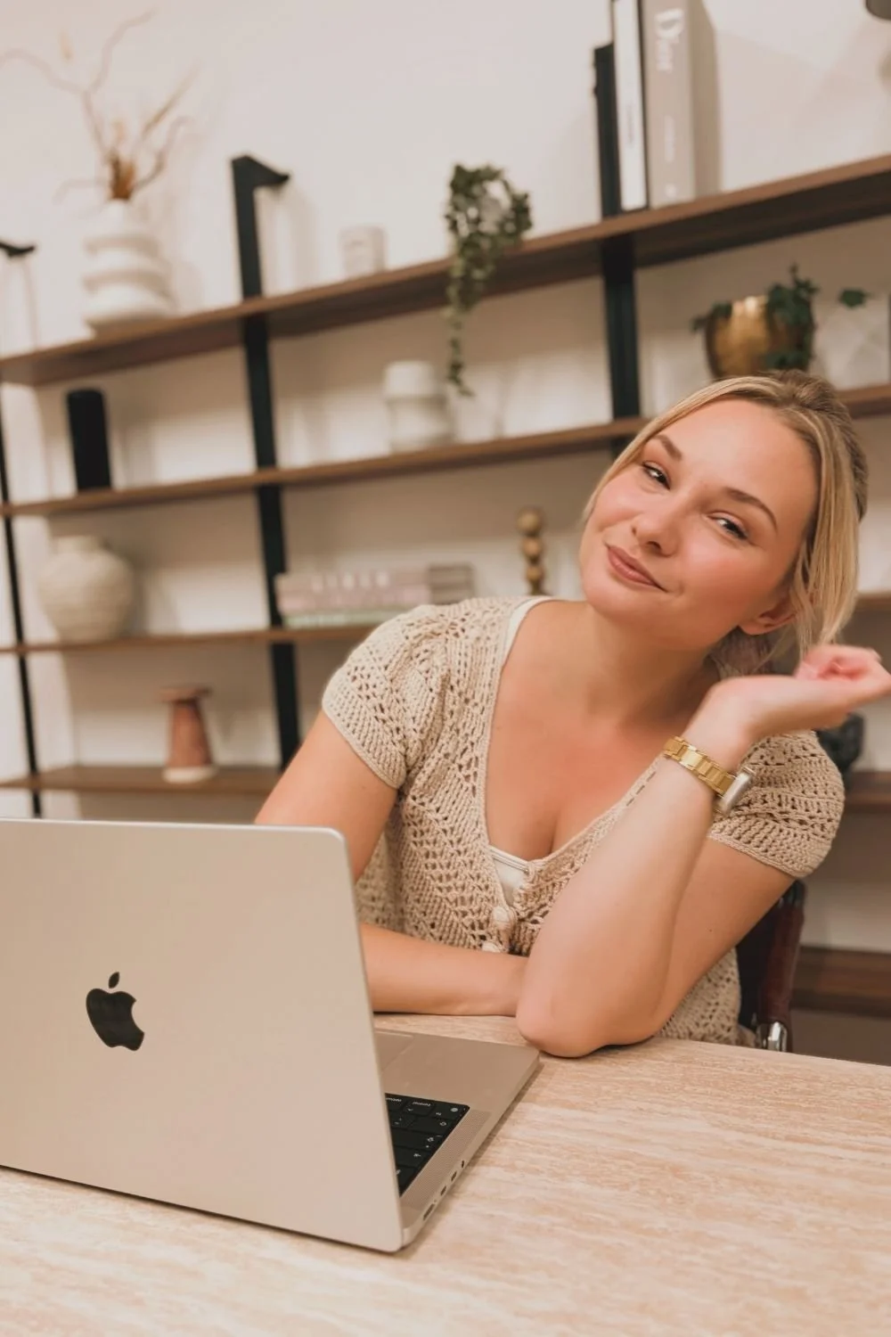 Naysha Gane smiling at her laptop in her home office