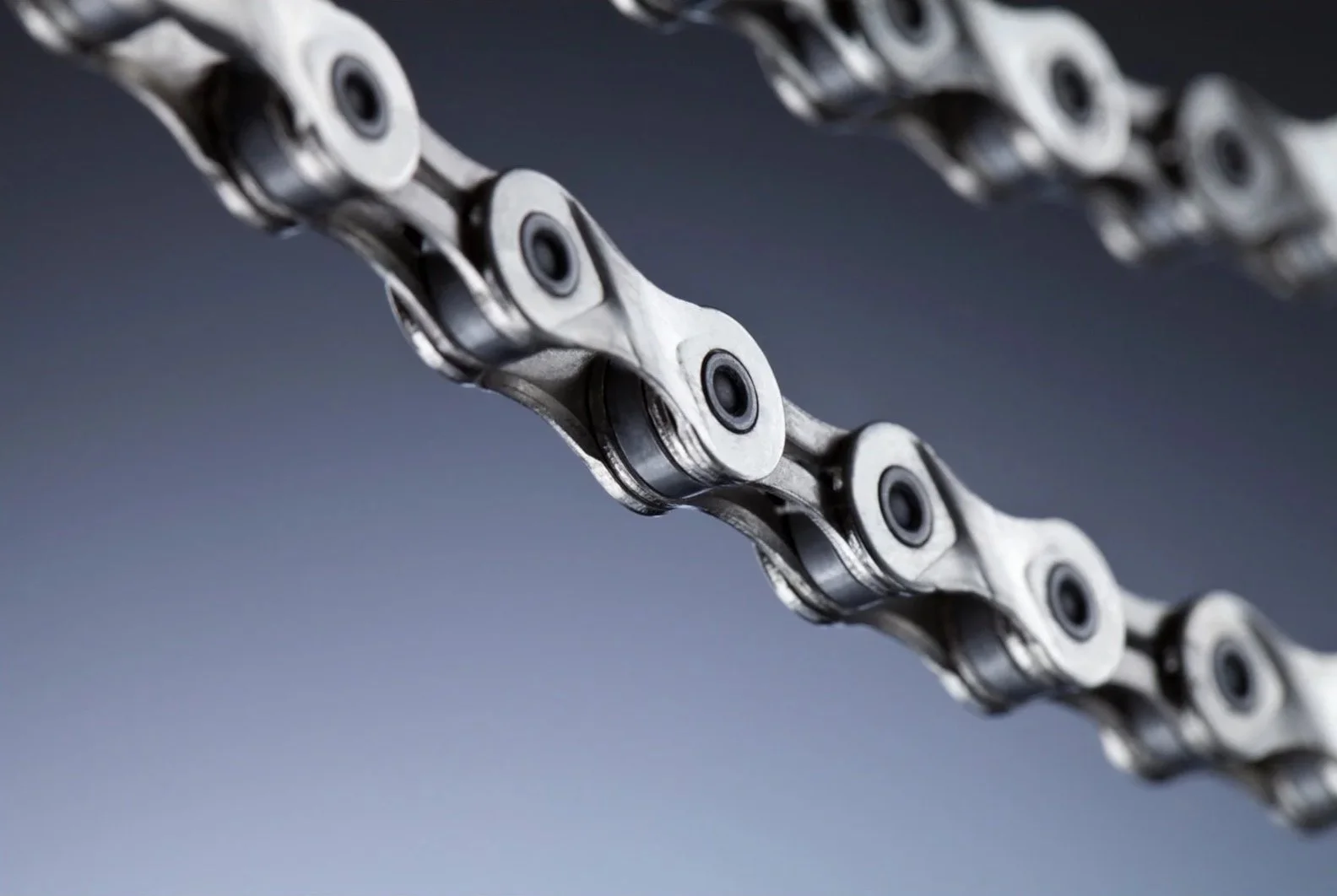 Close-up of a metal bicycle chain isolated on a gray background.