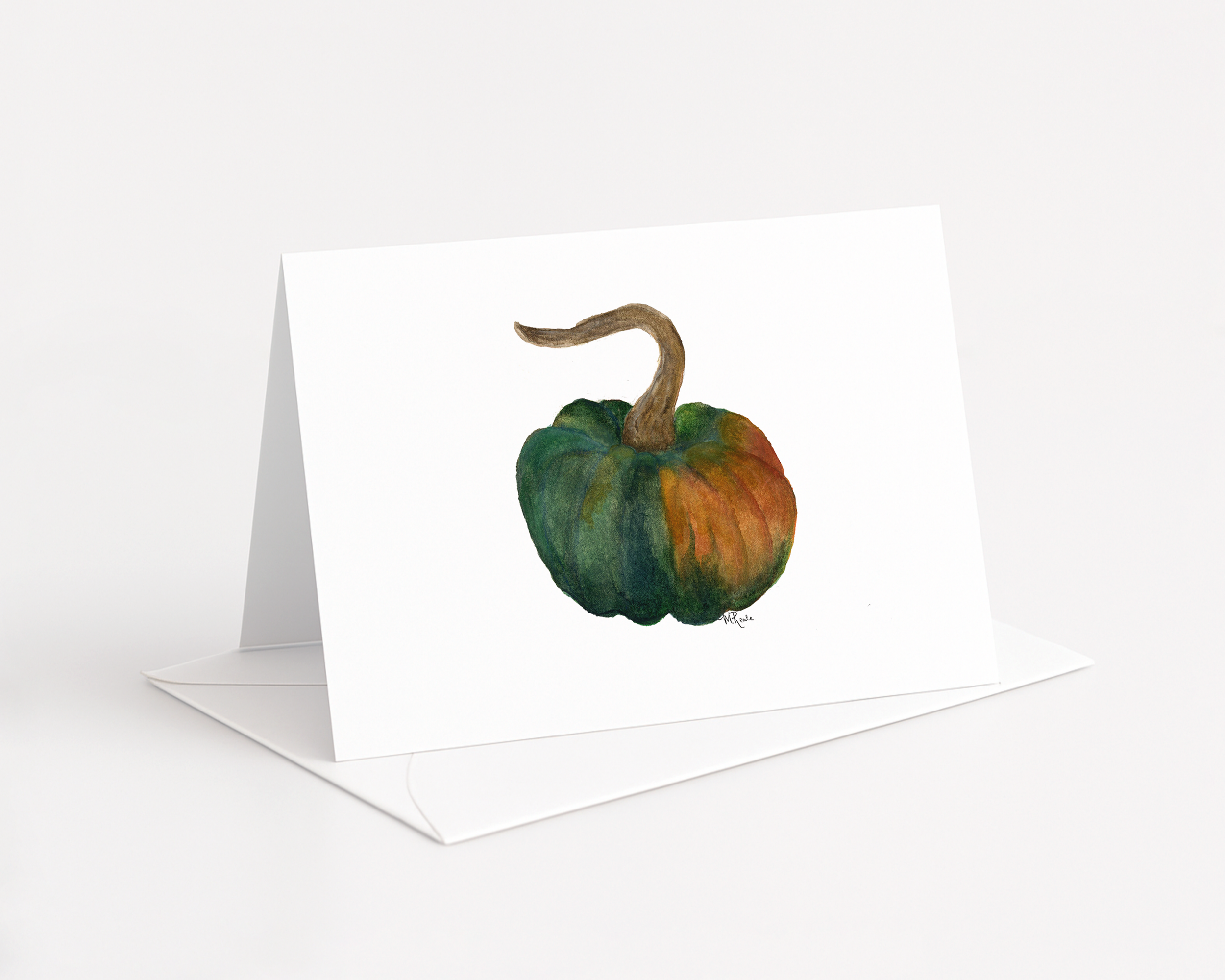 A colorful watercolor painting of a pumpkin with a green, orange, and brown color scheme, displayed on a white greeting card.