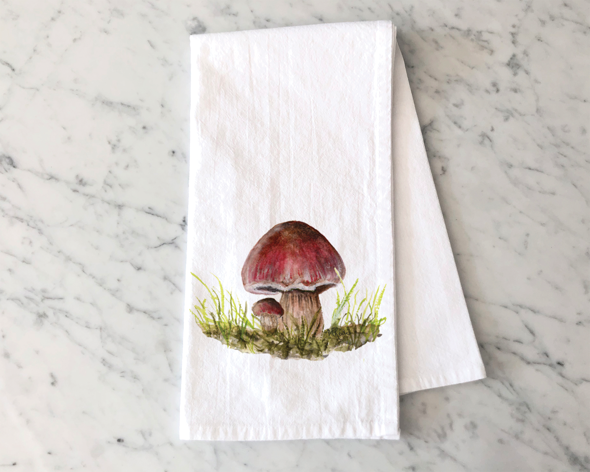 Watercolor painting of three mushrooms growing in grass on a paper towel, placed on a marble surface.