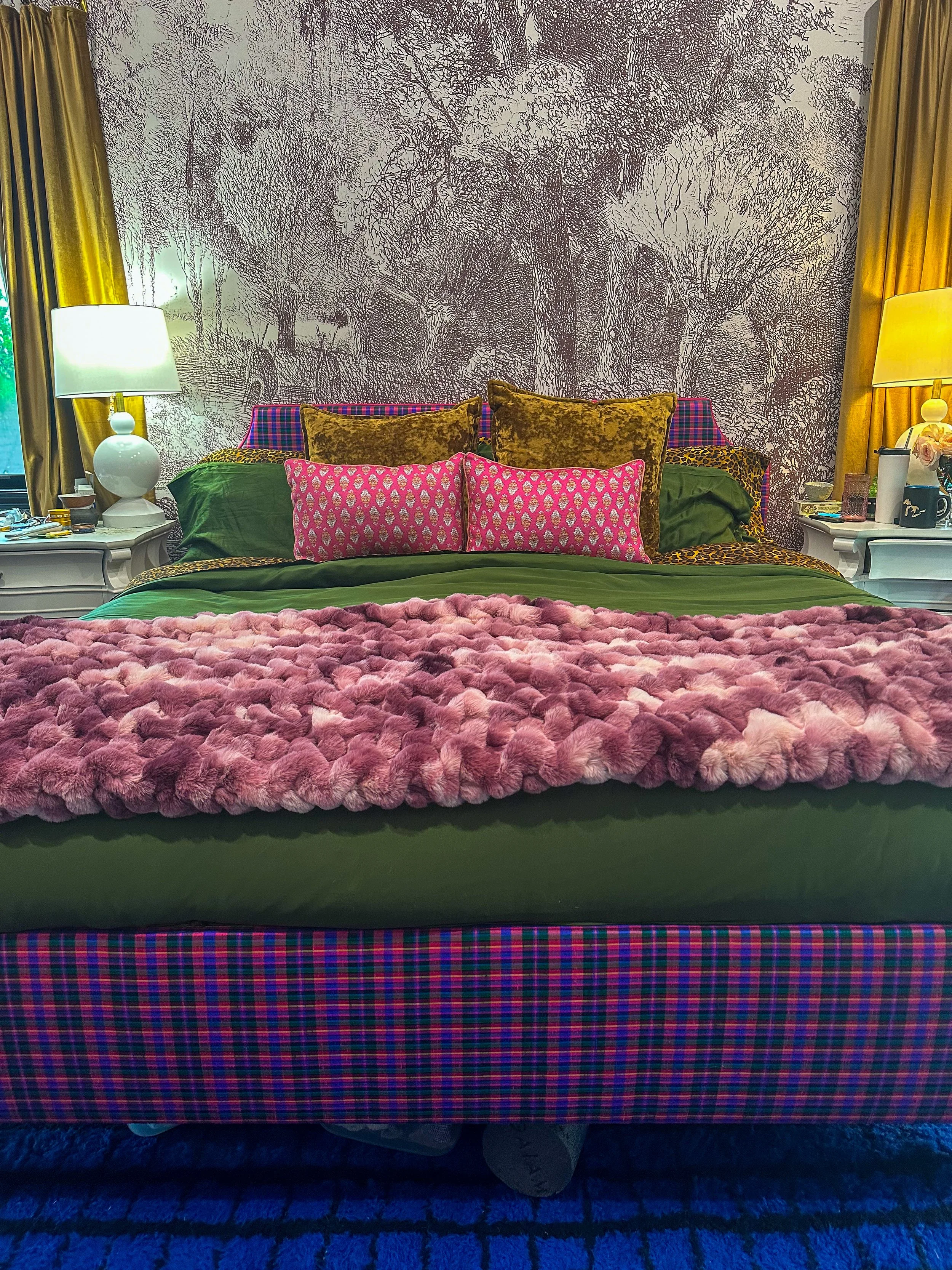 Moody layered bedroom featuring custom upholstered plaid silk fabric bed and headboard, dramatic mural and rich jewel tones.