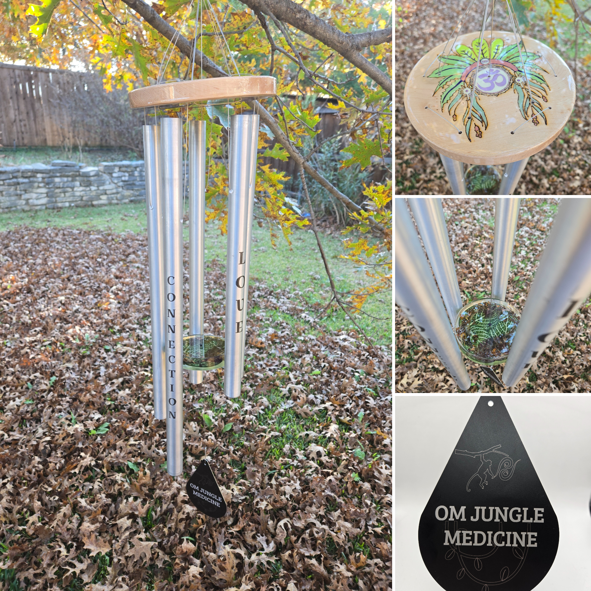 A wind chime made of four metal tubes hanging from a wooden top with painted green leaves and an OM symbol, set outdoors among fall leaves. The tubes have the words 'Connect' and 'Queue' written vertically on two of them. There is also a black teardr