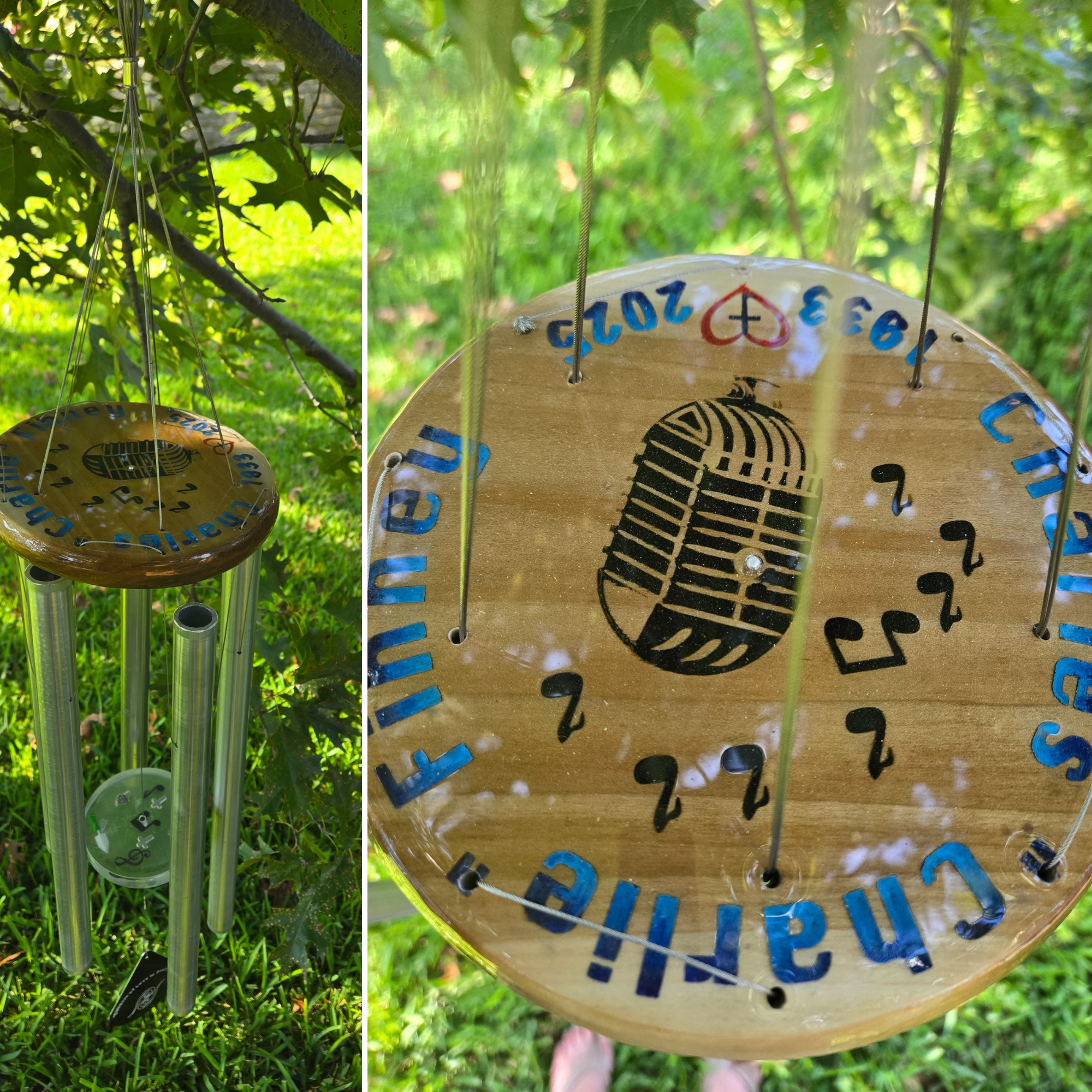 A weather vane with a musical microphone design, suspended among green trees with wind chimes hanging below.