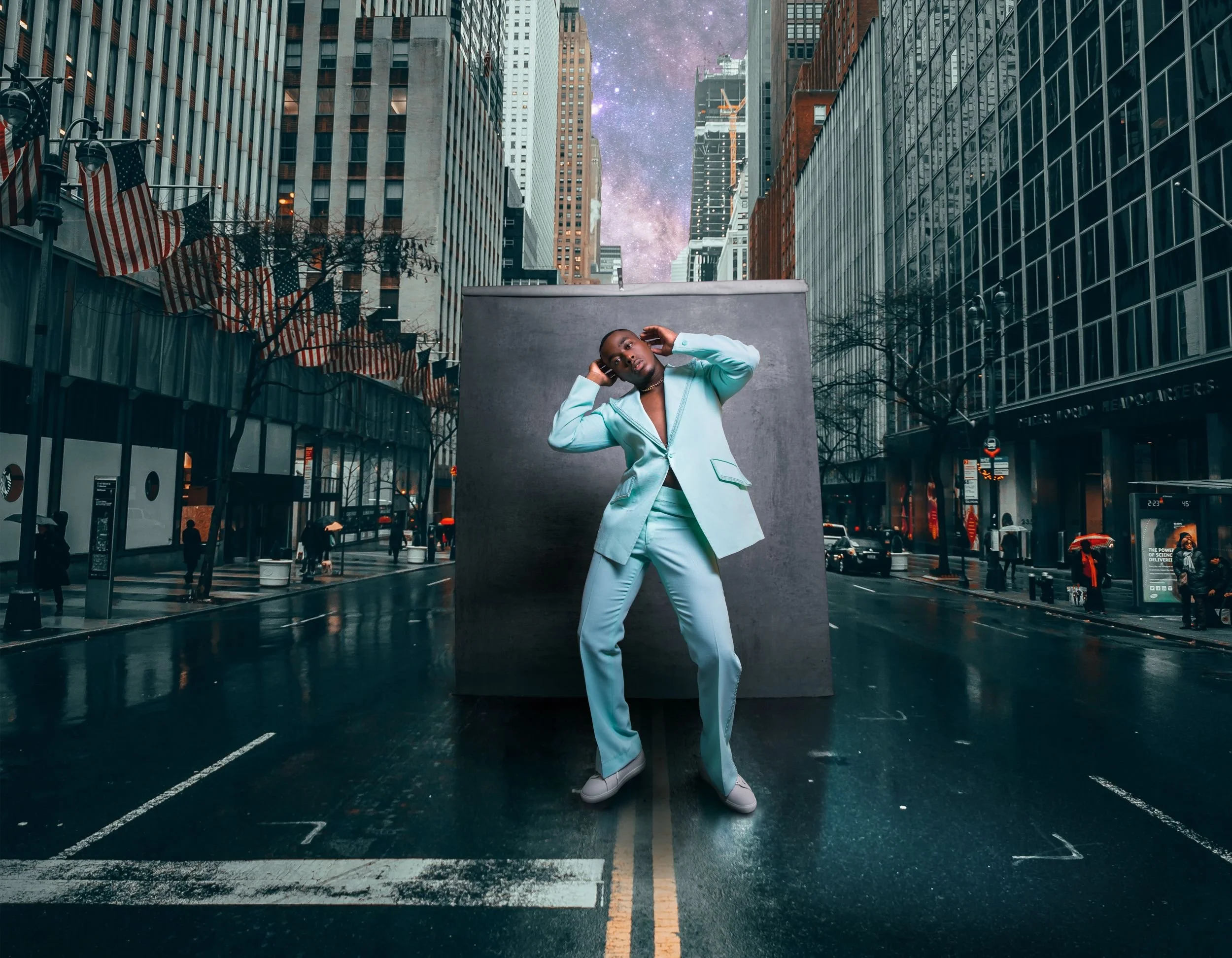 Person in mint green suit standing in the middle of a city street at night, with a gray backdrop behind them, tall buildings surrounding, and a starry sky above.