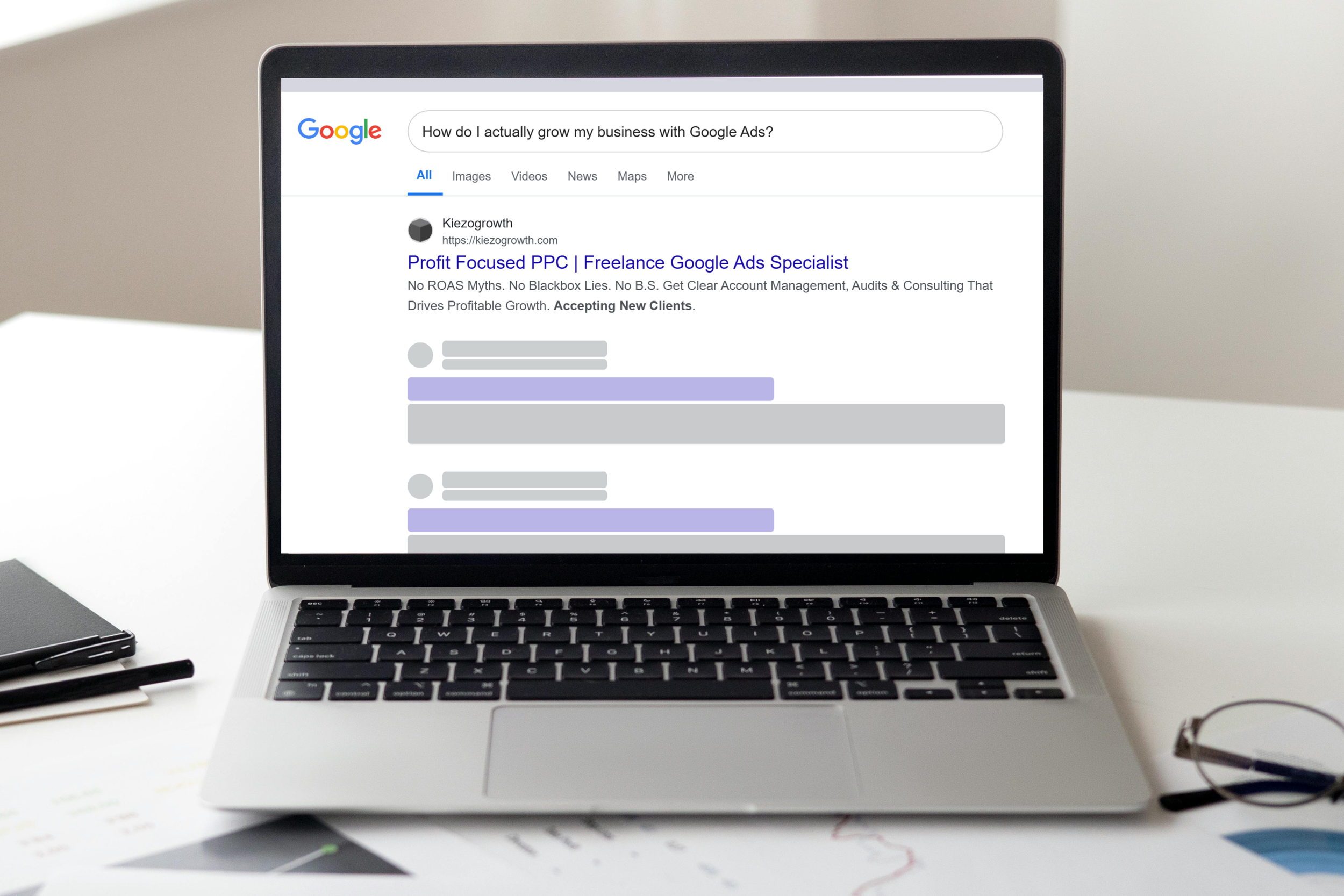 Laptop on a white desk displaying a Google search results page with a query about growing a business with Google Ads.